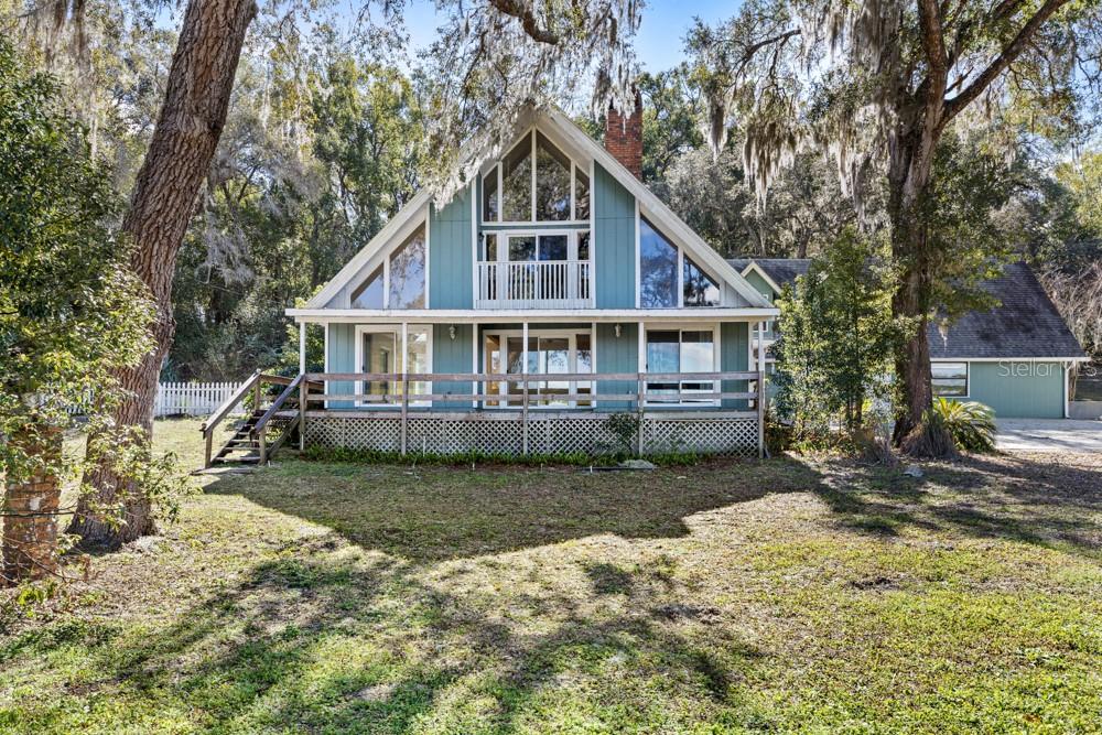 Located in Eustis and tucked away off Estes Road sits this remarkable 24+ acre estate. The property includes 2 buildings and a barn. The main residence features 4 bedrooms and 3 full baths, with a warm living and dining area anchored by a classic brick wood-burning fireplace. The second floor includes a large loft adjacent to the primary suite, complete with its own brick wood-burning fireplace. The main home offers peaceful views from every window in the home and the wide front porch that overlooks the pasture. The living room opens up to the private pool. Attached to the main home is a fully independent guest apartment, offering exceptional flexibility. It can function as a 2-bedroom/2-bath unit, or there is an opportunity to have 2 separate spaces. When the spaces are separated, they each have separate entrances, HVAC systems, and electrical meters, making it ideal for multi-generational living, rental income, or guest accommodations. The second building, separate from the main house and main house apartment, located on the property is an 1,800 sq. ft. block structure featuring an expansive commercial-grade kitchen. This space was used for training and educational purposes with the previous owners, and this building could easily be converted into a single-family residence, if desired. The property also includes a horse barn, and a shed for equipment storage. In addition to all of the features included in this property, a $200,000 renovation credit is being offered, providing an exceptional opportunity to make the space fit your unique needs. Call today to schedule your private tour.