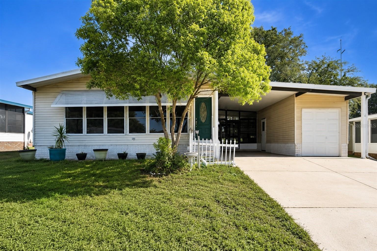 Relax, unwind, and enjoy the Florida lifestyle you’ve been dreaming of in The Villages! Nestled beneath beautiful mature oak trees, this charming 2-bedroom, 2-bath home offers the perfect blend of comfort, privacy, and opportunity. Step inside to a spacious, light-filled living room featuring a wall of oversized windows, while the enclosed Florida room provides the ideal spot to enjoy your morning coffee or a quiet afternoon overlooking the peaceful backyard.

Thoughtful updates have already been completed, while still leaving room to add your own personal style and build equity over time when making it your own. A spacious primary suite, golf cart garage, and tranquil outdoor setting complete the home.

Ideally located near all of The Villages’ renowned golf courses, recreation centers, pools, dining, shopping, and nightly entertainment, this home is the perfect opportunity to enjoy one of Florida’s most sought-after active lifestyle communities while making it your own.(DAMAGED WINDOWS HAVE BEEN REPLACED SINCE PHOTOS)