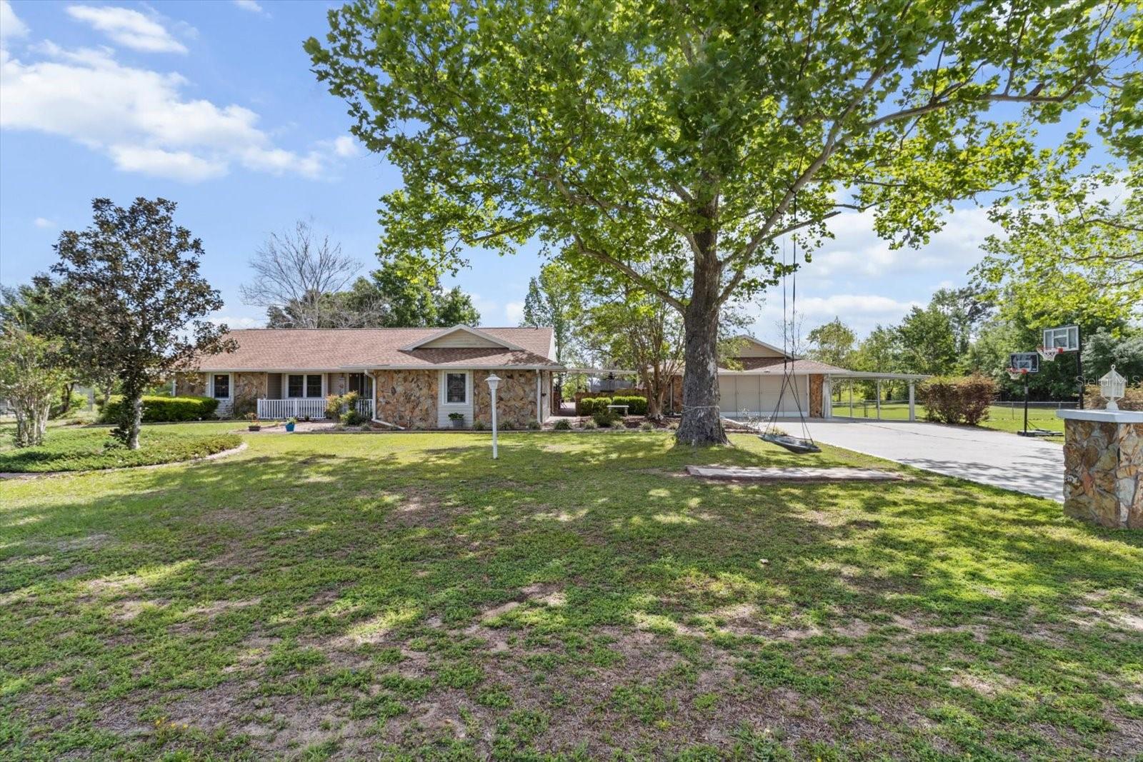 Welcome to your quiet countryside retreat, where comfort, space, and modern features come together on a beautiful 2.13-acre property. Set within the rural community, The Ranches of Inverness, this exceptional home offers the serenity of country living while remaining just minutes from everyday conveniences. Inside, you'll find a desirable split-bedroom floor plan featuring 3 bedrooms, 2 bathrooms, and a versatile BONUS ROOM that can easily serve as a 4TH BEDROOM, HOME OFFICE, GYM or PRIVATE GUEST SPACE. With its own SEPARATE ENTRANCE, this flexible space offers endless possibilities. The spacious living room is highlighted by soaring cathedral ceilings and a stunning wood-burning stone fireplace, creating a warm and inviting focal point. Major updates provide peace of mind, including a NEW ROOF (2020), NEW A/C SYSTEM AND DUCTWORK (2024), plus a smart Alexa-enabled thermostat for enhanced comfort and efficiency. Step outside and discover a property designed for both relaxation and enjoyment. The FULLY FENCED BACKYARD includes a dedicated dog run and beautifully landscaped grounds complete with a fire pit, flourishing vegetable garden, and an impressive collection of fruit trees and plants. Entertain guests on the expansive paver patio or relax beneath the covered breezeway that connects the home to the detached two-car garage. The huge, enclosed back porch with vinyl windows offers year-round living space and leads directly to a hot tub -wonderful for unwinding at the end of the day! Additional features include HURRICANE SHUTTERS, A WHOLE-HOUSE GENERATOR, A WATER SOFTENER SYSTEM, and FOUR STORAGE SHEDS, providing exceptional functionality and storage. Offering a rare combination of acreage, privacy, thoughtful upgrades, and outdoor amenities, this is a great home! Come experience the beauty, tranquility, and endless possibilities this countryside gem has to offer!