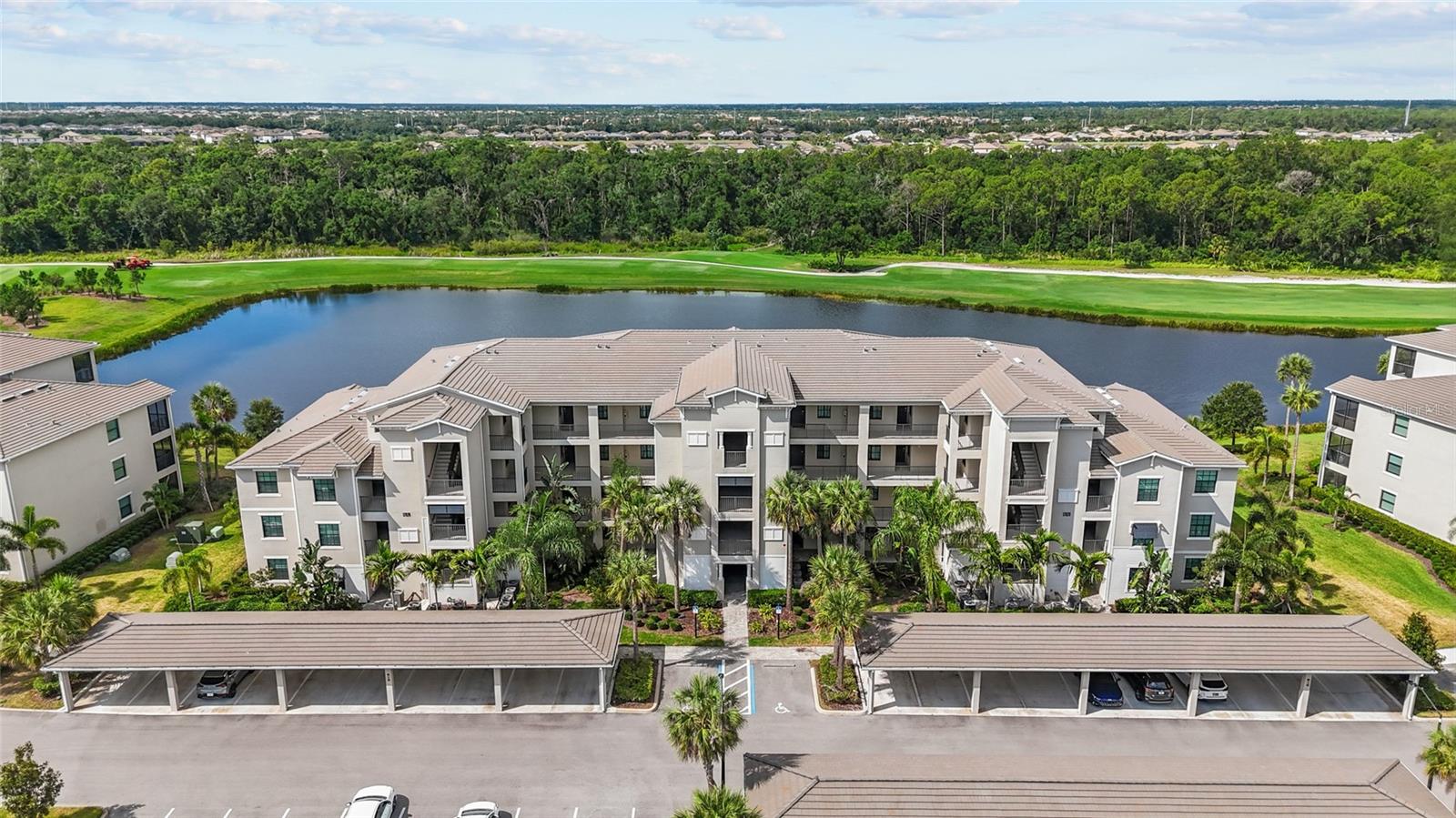 Experience resort-style living in this highly sought-after Lakewood National Golf Club community. Offering stunning lake and golf course views, this move in ready 2 bedroom & 2 bath (Pictures Shows one room as a Den.) Condominium combines comfort, stle, tasteful furnishings and décor throughout, in-unit washer and dryer, an elevator access, covered carport and a private storage closet and convenience in one exceptional package. The open-concept floor plan is filled with natural light and features a well-appointed kitchen with quartz countertops, wood shaker cabinetry, stainless steel appliances, a large, center island—perfect for everyday living and entertaining. The spacious living area flows seamlessly through sliding glass doors to a screened lanai, where you can relax and enjoy peaceful views of the lake and the Golf Course views. The property is well suited as a primary residence, seasonal retreat, or income-producing investment, with 30 day minimum rentals permitted up to 12 times annually. Lakewood National is a gated, 24-hour guarded community offering a premier resort lifestyle with two Arnold Palmer designed 18-hole golf courses, host of the PGA LECOM Suncoast Classic, and a Grand Clubhouse featuring fine dining, a zero entry resort style pool with lap lanes, heated spa, tiki bar, poolside café, restaurant, tennis and pickleball courts, fitness center, full-service spa, and miles of walking trails. Ideally located in Lakewood Ranch, recognized as the number one multi-generational community in the United States for five consecutive years. Residents enjoy a vibrant social atmosphere with upscale shopping and dining, polo matches, art festivals, farmers markets, and more.