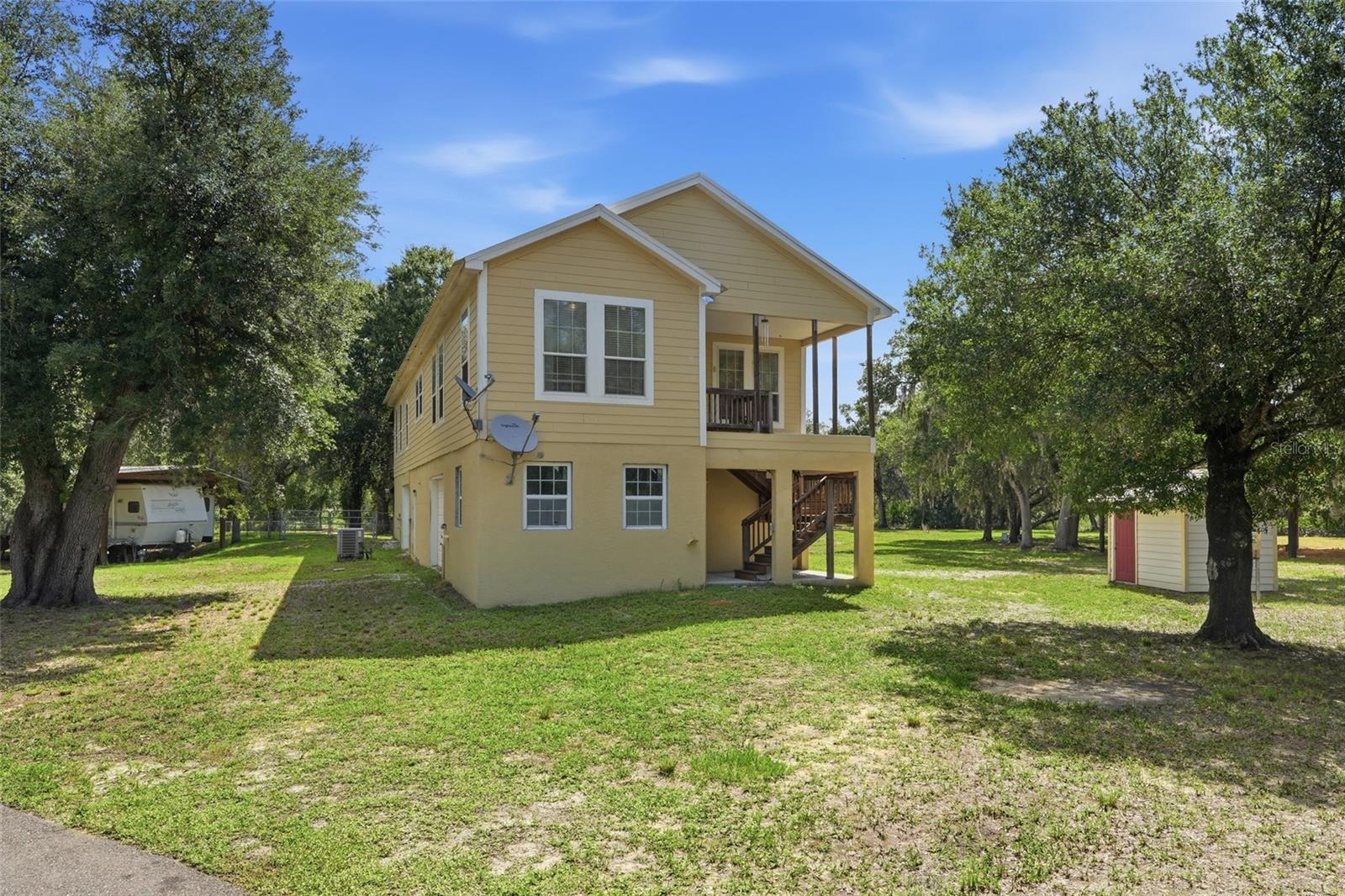Tucked away at the end of a beautiful tree-lined driveway, this one-of-a-kind property offers the privacy, space, and charm you've been searching for. Situated on approximately 5 acres and zoned for animals, this property is ready for everything from hobby farming to simply enjoying a little extra elbow room and country living. The home occupies the entire second level and features a thoughtfully designed split-bedroom floor plan with three bedrooms and two bathrooms. Inside, you'll immediately notice the gorgeous wood floors, abundant natural light, and welcoming living room complete with built-in shelving and a fireplace that creates the perfect gathering space. Storage is plentiful throughout, including a spacious indoor laundry room and an oversized hallway closet. The kitchen is truly the heart of the home and a dream for anyone who loves to cook or entertain. Complete with granite countertops, a center island, breakfast bar, and an impressive amount of cabinetry, there's a place for everything. Just off the kitchen, you'll find a charming breakfast room with access to a private deck overlooking the property, making it the perfect spot for morning coffee or evening sunsets. The dining room is equally impressive with unique Florida-inspired wallpaper and beautiful natural lighting that makes every meal feel special. The oversized primary suite offers plenty of room to unwind, along with a massive walk-in closet and spacious en-suite bathroom. Downstairs, the entire first floor is dedicated to an incredible 5-car garage with endless storage possibilities for vehicles, equipment, toys, or workshop space. Outside, the opportunities are endless. With approximately 5 acres of land, a pole barn already in place, and zoning that allows animals, this property is perfectly suited for those dreaming of a mini farm, equestrian setup, or simply enjoying the peace and freedom that comes with country living. Properties offering this much space, storage, and versatility don't come along often. Come see what life could look like when home feels like your own private retreat.