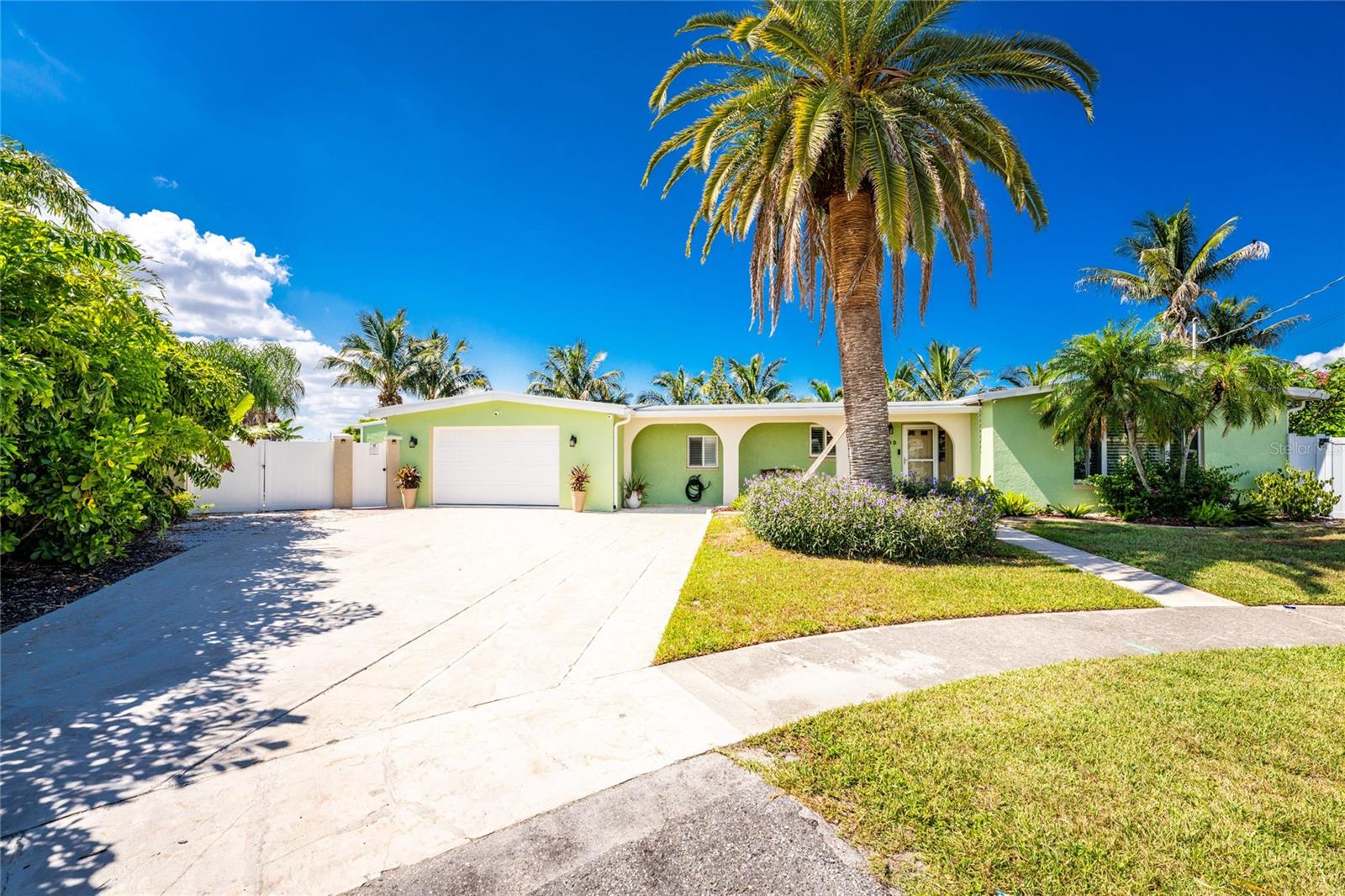 The inside of this 3 bed 3 bath very private, waterfront, screened solar heated pool home did not flood. 238 ft tip lot with very mature, beautiful landscaping. IMPACT windows and doors throughout. Newer roof (2022). Oversized 2 car garage. The family chef will love the two full size ovens in a large, very functional kitchen. All three bedrooms with solid core doors are absolutely huge. Easy possibility for a fourth bedroom. Primary bathroom has a spa tub, double sinks, walk in shower and closet. Two tankless hot water heaters run it all. Two zone A/C as well. High end ceiling fans throughout along with plantation shutters on all the windows. Updated PVC plumbing to the street,  No cast iron.  Watch tv under your covered lanai or on the built-in big screen by the pool. Only a few minute boat ride to wide water and the harbor. Nicely landscaped, oversized lot just under a half acre. You'll feel like you're at a resort in the evening with the landscape up-lighting showing off most of the 23 mature palms in your fenced backyard. ONE OF A KIND home very close to the harbor. Importantly, not a lot of mangroves around, so mosquitoes and no see ums have never been an issue unlike a lot of subdivisions on the harbor.  Canary palm in the front can stay or go.  There's an open offer to buy the tree from Sunscape Landscape & Nursery.