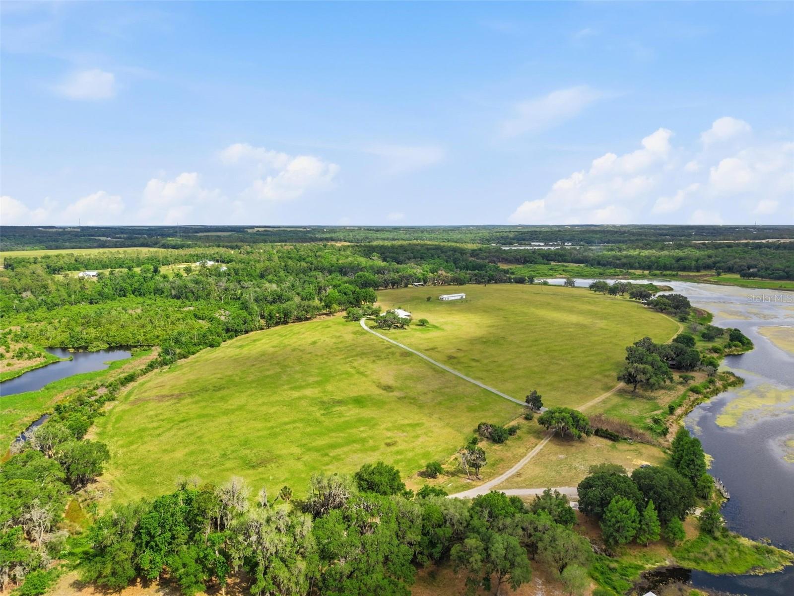 Welcome to an extraordinary 107-acre legacy estate where rolling hills cascade gently toward a breathtaking spring-fed lake, creating one of the most captivating landscapes in all of Central Florida. Tucked away in the peaceful countryside yet remarkably close to the energy of Tampa and the leading hospitals and conveniences of North Tampa, this is the rare kind of property that simply no longer exists.

As you enter the estate, majestic century-old live oaks frame the winding landscape like scenes from a classic Southern film. Elevated hilltops reveal sweeping 180-degree west-facing lake views, delivering unforgettable sunsets that paint the water in gold each evening. The pristine spring-fed lake offers exceptional bass fishing, kayaking, small boating, and the kind of peaceful waterfront lifestyle most only dream about.

At the heart of the property sits a stunning Southern-style lake home filled with warmth and timeless charm. Expansive wraparound porches overlook the water, inviting you to slow down and take in the beauty of the land from sunrise to sunset. The lake home features 4 bedrooms, 3 full bathrooms, 2-car garage + fireplace and a private mother-in-law suite complete with its own one-car garage — ideal for extended family, guests, or multigenerational living. There is a second home on the property (manufactured home).

Down by the shoreline, a storybook boathouse feels as though it was lifted straight from a Nicholas Sparks novel — shaded beneath towering live oaks that took generations to become this magnificent. It is the perfect gathering place for family and friends, offering lake access for kayaks and small boats, unforgettable entertaining spaces, and an atmosphere that cannot be recreated.

Beyond its beauty, the possibilities here are truly exceptional. The acreage may be divided into multiple parcels, making it ideal for creating a private family compound or an exclusive country estate community featuring luxury lake homes and shared lake access. The combination of elevated topography, mature oak hammocks, open pastures, waterfront views, and development potential makes this property extraordinarily rare.

Properties like this are not man-made — they are created by nature over generations. The rolling hills, majestic oaks, sparkling spring-fed waters, and cinematic scenery come together to create a place that leaves a lasting impression long after you visit.

This is more than land. This is a once-in-a-lifetime opportunity to own an unforgettable Florida legacy property.

The peaceful lakefront location could not be any better with quick access to Tampa for those who work there but want to live outside of the city and rather belong to a small town with a community-feel! The property is located close to both Historic Dade City and Brooksville in the highly-desired area of Spring Lake. This area in on a ridge of hills offering long distance views that will make you forget you're in Florida and yet you're just minutes from I-75. These are two "Hallmark Towns" with year round festivals, arts and craft shows, music on the town square, horse-drawn carriage rides at Christmas, coffee shoppes, charming stores and restaurants!! 30 minutes to kayaking, paddle-boarding, and swimming with the manatees in the clear Weeki Wachee River! Enjoy all the water activities Tampa offers from! 1 hour to TOP US BEACHES!! 1.5 hours to Disney World and Universal Studios and all the theme parks!! You can really have it all.