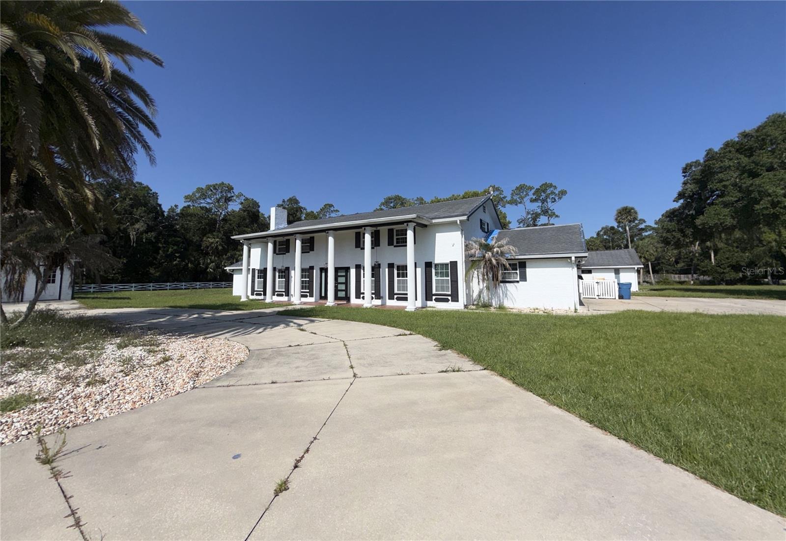 More photos are coming. This unique 5-acre property offers plenty of space inside and outside and has other great features that are hard to find.  The 5,300 sq. ft. home offers 4 to 6 bedrooms, 4 full baths, 2 half baths, 2 possible en-suites, a huge kitchen with center island, a family room, formal living and dining spaces, an oversized great room with beautiful, beamed ceilings, a possible game or theatre room, an office, inside laundry, along with several other flex rooms and an attached 2-car garage.   The flexible floor plan can work well for multi-generational living, a home-based business, distinctive guest spaces, hobby spaces, or ample living space for anyone who simply needs lots of room to really spread out. Some remodeling has already started, leaving the new owner with opportunity to finish the home their way and gain some sweat equity. Outside, the property offers an enormous pool deck with a tiki bar, a 22 x 44 pool, private tennis/racquetball court, and a detached 3 to 4-car garage great for vehicles, equipment, storage, or recreational toys. The cleared 5-acre parcel offers room for gardening, animals, outdoor projects, or future improvements. This property is priced with missing finishes in mind and room for some possible land drainage improvements. This is a good opportunity for a buyer looking for acreage, privacy, storage, and unlimited potential, all for a reasonable price.  Thinking it could work for you? Come see it today!  There are no warranties expressed or implied.  All measurements are approximate.  Sq. footage received from the tax rolls.  All information recorded in the MLS is intended to be accurate but cannot be guaranteed.  Buyers should check zoning for rental restrictions.