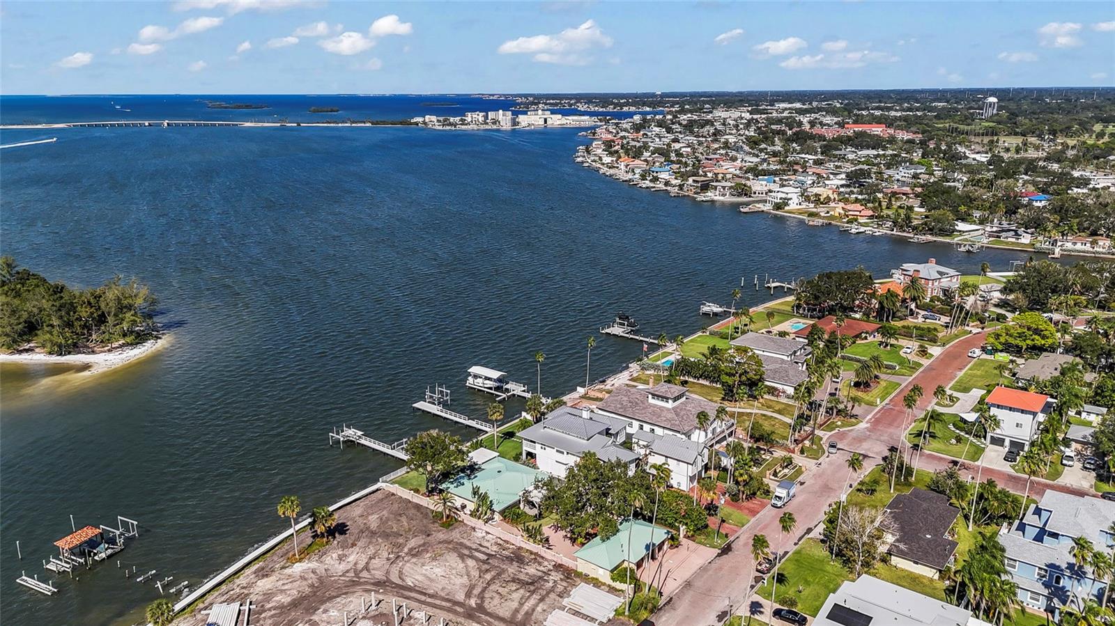 Sweeping views from this waterfront paradise. A rare and highly desirable deep-water property in delightful Dunedin with direct intracoastal access! Wow, what a find! This 3-bedroom, 3 bath home offers a truly open-concept layout with over 2,100 sq ft of living space. An entertainer’s delight with a large modern kitchen featuring stainless appliances, a farm style sink, gorgeous cabinetry with pan drawers, pantry cabinet and upgraded hardware, quartz counters with tons of counter space and a beautiful designer backsplash stretched to the ceiling. Two of the bedrooms boast ensuite baths and the third bath is conveniently situated for guests.  The bathrooms are modern and include designer tilework. Wood-look tile flooring runs throughout the home for a cohesive and modern feel. Entertaining space is extended to a screened porch looking out on an absolute wonderland… waterfront living at its finest. Large backyard leads to a boater’s dream… a composite dock equipped with 10,000 lb. boat lift and an additional platform lift for two jet skis, as well as an area to sit and take in the beauty of a waterfront sunset! Cheers to living your dream! Recent updates include a new central A/C system and standing seam metal roof. The property features a private gated entry and a 3-car garage for added security and convenience. It is wired for a generator. Enjoy dolphins, manatees, breathtaking sunsets, and quick access to the island just across the intracoastal. All of this in thriving, sought after Dunedin. Enjoy the charm of the city’s vibe and fabulous restaurants, shopping, entertainment, sports and festivals. Near to medical, easy access to airports and of course the famed Gulf beaches are your backyard playground! Make it happen… make it yours and live that fabulous Florida lifestyle.