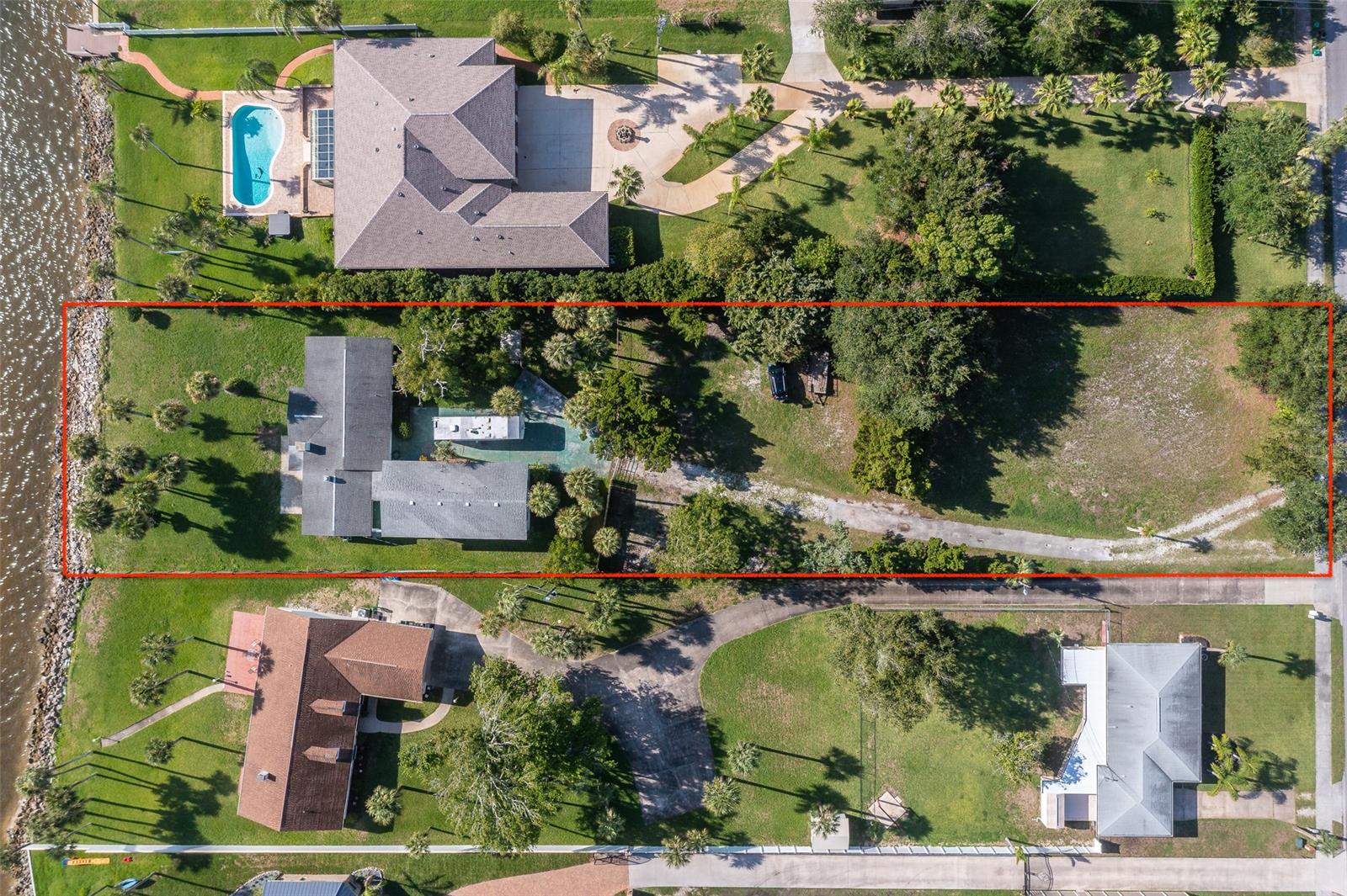 Priced for immediate sale. Estate Lot 100’ X 448’ (OVER 1 ACRE) on the International Coastal Waterway. On this Estate Lot, picture your new Estate Home surrounded by million dollar-plus homes. Watch the beautiful Daytona sun-rise over the International Coastal Waterway. Watch the dolphins, manatees, sea-turtles and sea-life right from your large back yard. Want to watch all rockets launched from Cape Canaveral? Watch from your own back yard!  Watch the Florida Seabirds while sipping a refreshing drink. This large lot has room for growth by adding a swimming pool or dock. Launch your boat at Riverfront Veterans Memorial Park which is .2 miles south of this property. Waterfront entertainment possibilities galore; fishing, paddle boarding, kayaking, grilling your fresh catch while playing corn hole or horseshoes! Built in 1956, the house still stands and the bones are good! The home has the original hardwood floors, cabinetry, vintage paneling & retro bathrooms ready to be brought back to life. Park your RV/camper while you remodel. RV/Camper/boat concrete slab & pump-out beside the garage. The possibilities are endless. The  house has 3 bedrooms, 1 full bath & 1 half bath. Enjoy the brick corner two-sided fireplace on those Cool Daytona Nights while the moon rises over the horizon as it reflects on the water. The detached garage has 976 Sq Ft. Storage over the garage has 1104 sq ft. . Make this property your own. ;Water: City