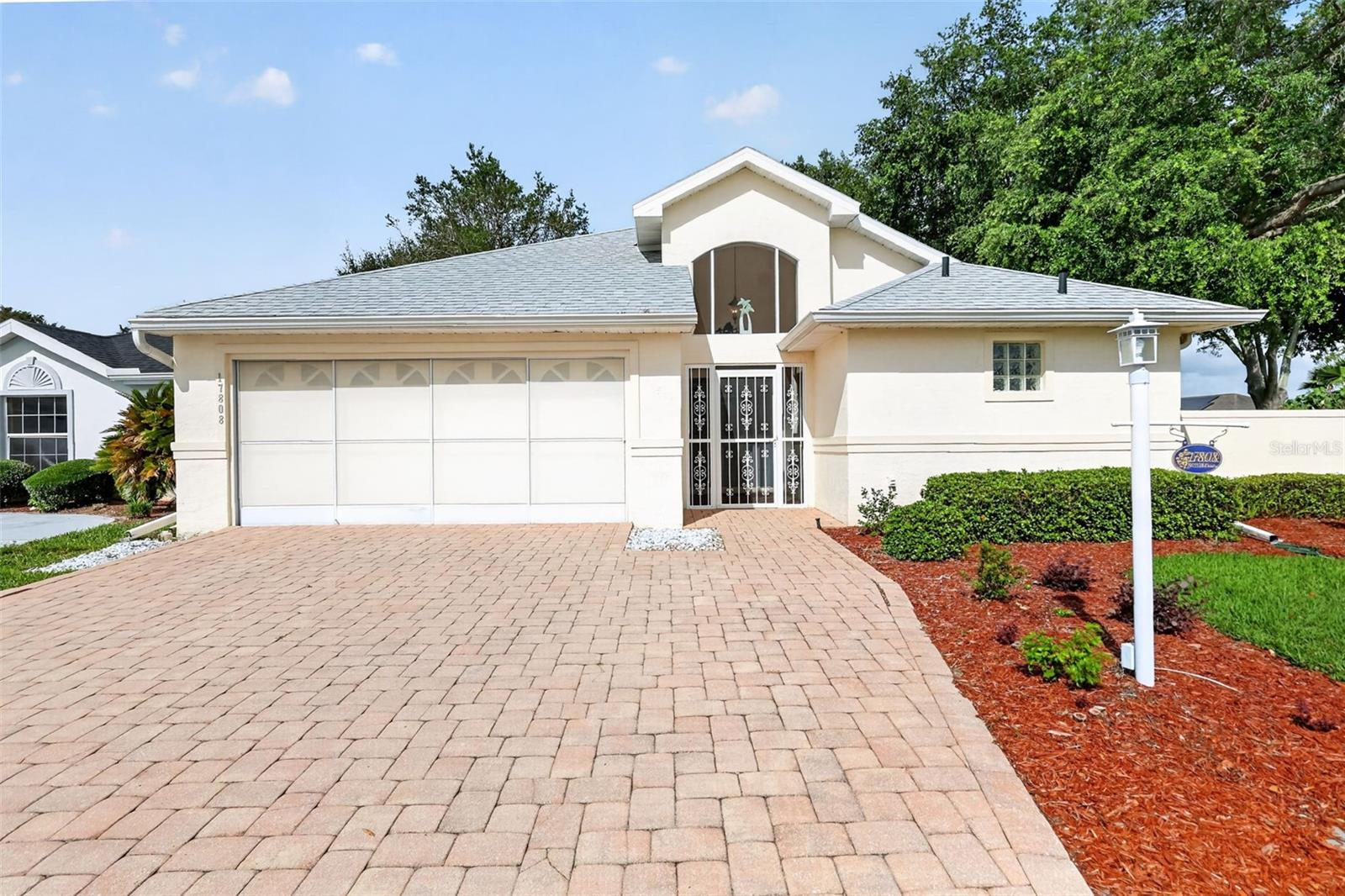 One or more photo(s) has been virtually staged. Beautiful 3-Bedroom, 3-Bath Courtyard Villa in Stonecrest! Located on a corner lot in the sought-after 55+ gated golf community of Stonecrest, just minutes from The Villages, this block and stucco home offers 2,282 sq. ft. of comfortable living space. The HOA covers lawn maintenance, shrub trimming and sprinkler system maintenance for easy, low-maintenance living. Inside, you'll find two spacious primary suites, each with a walk-in closet and en-suite bath, providing flexibility for guests and many possibilities  making it ideal for a variety of living arrangements. Primary Suite 1 features a walk-in shower, garden tub, dual sinks, and linen closet, while an additional linen closet is conveniently located outside the third bathroom.

The well-designed kitchen offers granite countertops, a skylight for abundant natural light, ample cabinetry and counter space, stainless steel appliances, and a breakfast bar for casual dining. The adjacent 8x12 dining area features an upgraded light fixture and a convenient pass-through window, making entertaining easy. The expansive 15x31 great room provides plenty of space for gatherings, while laminate and tile flooring throughout means no carpet. Additional updates include a 2020 roof, 2018 HVAC system, four new windows in 2021, and an inside laundry room enhanced by a solar tube for natural light.

Step outside to enjoy your private courtyard with beautiful landscaping and gardens. Mature trees provide welcome shade, and the community-maintained lawn stays lush and green year-round. Stonecrest offers exceptional resort-style amenities, including one indoor pool, three outdoor pools, pickleball courts, a softball field, fitness facilities, and clubs for nearly every interest. Conveniently located near shopping, restaurants, medical facilities, the VA, and everyday services, residents also enjoy golf cart access to Walmart, Aldi, Cracker Barrel, Lowe’s, and more. This is Florida retirement living at its finest!