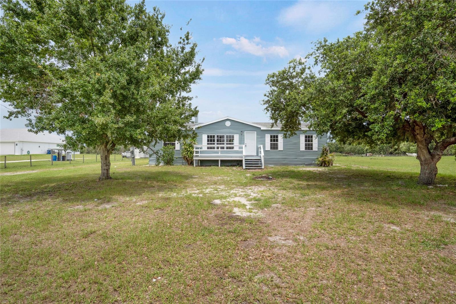 Welcome to peaceful Myakka City, where wide-open spaces meet the comforts of home!

This charming 3-bedroom, 2-bath country retreat is nestled on 5 serene acres, offering the perfect blend of privacy, functionality, and rural charm. Whether you're looking to settle into quiet country living or need space for your hobbies, animals, or outdoor adventures, this property has endless potential. Step inside to a bright, open floor plan with fresh interior and exterior paint, no carpeting, and thoughtful updates throughout—including new lighting, plumbing improvements, and hurricane-impact sliders. The heart of the home is the spacious living room with a beautiful fireplace centerpiece, ideal for cozy gatherings.

Off the living area, you'll find a large den to the right—perfect for a home office, playroom, or guest space—and the dining room and kitchen straight ahead. The kitchen flows effortlessly into the living space, making it ideal for entertaining.

The primary suite is located to the left of the home and features a spacious walk-in closet, his and hers sinks, a soaking tub, and a separate shower. On the opposite side of the split floorplan are two generously sized guest bedrooms and a full bathroom, with a conveniently located indoor laundry room just down the hall.

Enjoy your morning coffee on the updated front or back porch while taking in the tranquil views of the pond and expansive acreage. Out back, a massive 30x40 workshop (2019) offers the perfect setup for your RV, boat, toys, or next big project. There's also a separate shed with power, windows, and cabinetry—ideal for extra storage or a potential hobby space.
Outdoor enthusiasts will love the proximity to Duette Preserve, known for horseback riding, fishing, and wildlife viewing. You're also just minutes from the Manatee Gun & Archery Club. Best of all, this property is not in a flood zone, and there are no HOA or CDD fees—giving you the freedom to truly make it your own.

Don't miss the chance to own this slice of country paradise—schedule your private showing today and discover all the possibilities that await!