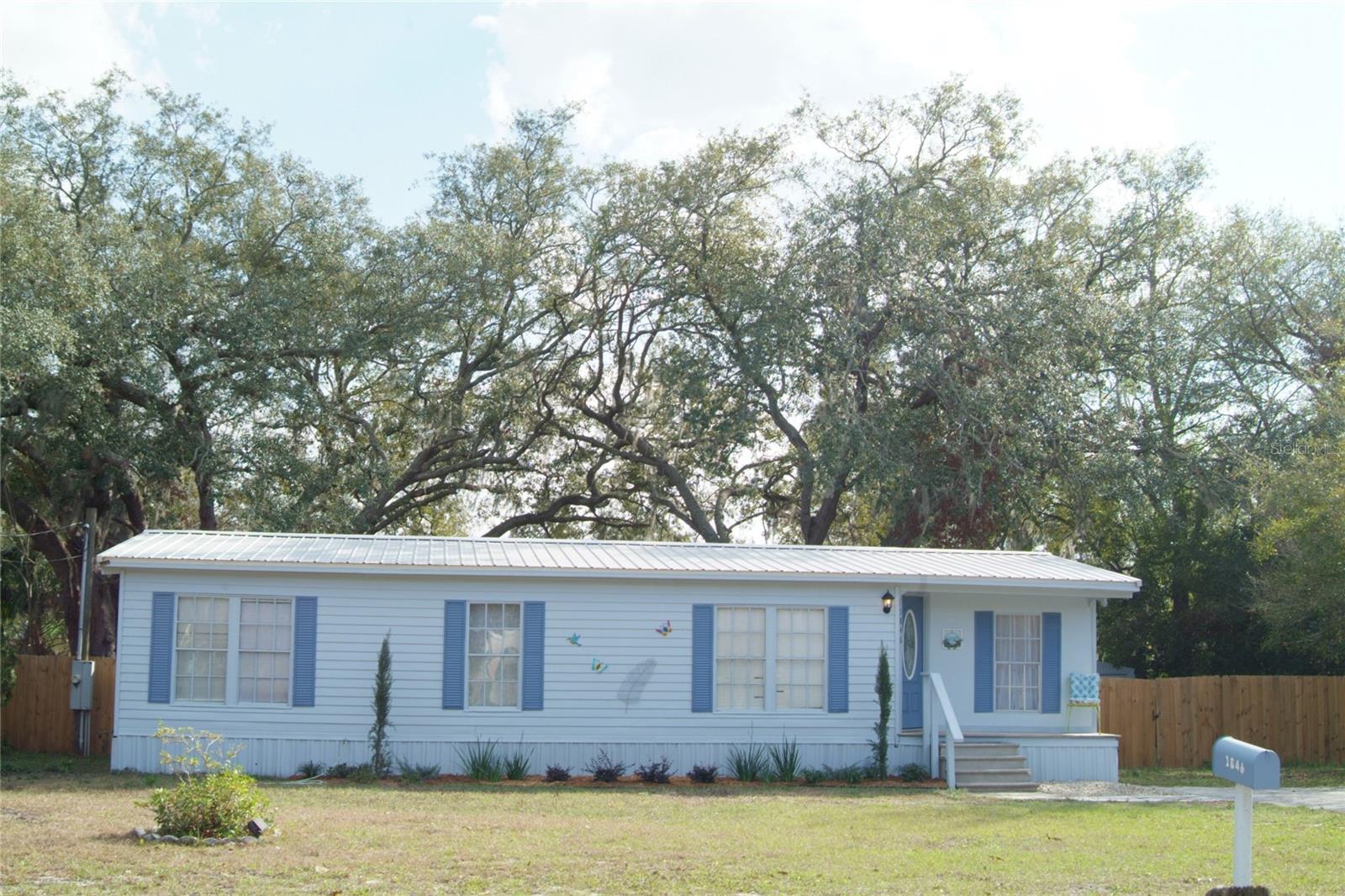 Home Buyer/Investor Alert! This home is a completely renovated 3 Bedroom, 2 Bath on 1/3 acre of your own land with fenced backyard located 1/2 mile from the very center of The coveted Villages. You own the land so No HOA. No monthly Lot Rent!!! No Subdivision Rules! This awesome property could be your personal home, your winter escape, or your rental cash flow dream. This house is located close to every amenity imaginable within a 5 to 10 minute drive yet has the peaceful feeling of being way out from town. Currently a successful 5.0 star furnished vacation rental listed on Airbnb, you could keep it as a nightly rental, switch it into a pad split and rent the 3 bedrooms each separately, switch it to a monthly or yearly rental, buy it for your own vacation/winter residence and rent it the rest of the year, or buy it and live in it full time. Residential buyers, retired/winter residents, or investors... All of you could enjoy and benefit from this completely remodeled 3/2 home. With great fenced back yard with mature landscaping & beautiful curved oak trees, cute front & rear covered porches, peaceful neighborhood with long term residents, NO HOA rules or fees, and close to Everything in The Villages and on Hwy 441 in Fruitland Park, Lady Lake, and Leesburg, you would be so happy with this home purchase. This house also boasts GREAT neighbors!!!
House has been completely remodeled over a 3 year period from 2023-2025...with more additions in Winter of 2026  Renovations include: 40+ year metal roof (2023). 2 new bathrooms with tub/shower combos with ceramic tile, new vanity and water closet in spare bath, 2 new his/her sinks, countertop, & water closet in master bath, laminate and linoleum flooring, new kitchen real wood cabinets, new kitchen island, new water heater, new granite countertop on cabinets and butcher block countertop on island (2025), new lighting, electrical outlets, and switches, new interior and exterior paint, new landscaping in front yard (2025), wooden back deck, water heater, and more. In the Winter of 2026, a water softener/purifier system & a charcoal filtration system were added, 3 new A.C Units, new dishwasher, and outside plumbing cleanout. The septic tank was recently pumped out as well. House is going to be sold partially furnished if the new owner wants to keep the furniture. Otherwise, the furnishings can/will be removed. Call today to schedule your showing of this lovely home.