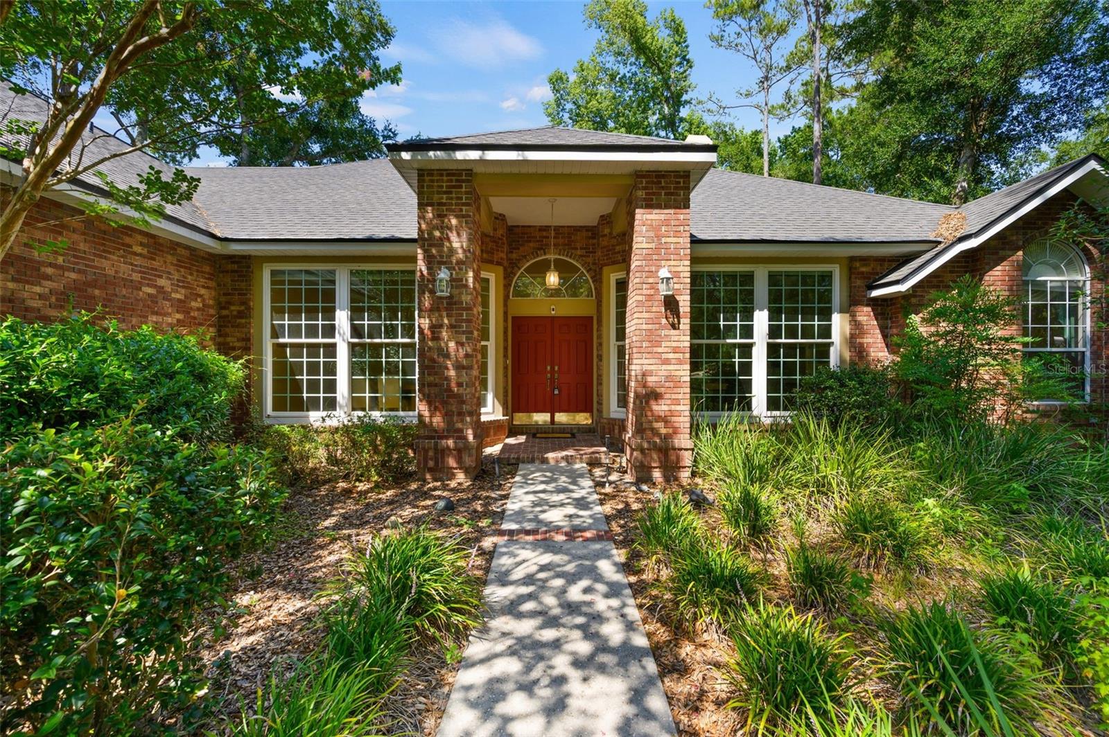Welcome to this beautifully crafted custom home in the centrally located Willow Creek community, where soaring ceilings and abundant natural light create a warm and inviting atmosphere. With no HOA, Willow Creek offers exceptional convenience to Glen Springs Elementary, the University of Florida, shopping, dining, and more.

Designed for both comfortable everyday living and effortless entertaining, the thoughtfully planned three-way split floor plan features a formal living room with custom built-in shelving and a formal dining room highlighted by a beautiful Busby corner cabinet. At the heart of the home, the spacious great room showcases rich wood flooring and a classic brick wood-burning fireplace, creating the perfect gathering space.

The well-appointed kitchen is a chef's dream, featuring new appliances, Corian countertops, a center island illuminated by a skylight, custom Busby cabinetry, tile flooring, a generous pantry, and abundant workspace for meal preparation.

The private owner's suite is a true retreat, offering a cozy sitting area, soaring ceilings with crown molding, dual closets, and a luxurious en-suite bath complete with a jetted whirlpool tub, separate walk-in shower, dual vanities with custom cabinetry, and premium finishes throughout.

Bedrooms two and three share a convenient Jack-and-Jill bathroom, while the fourth bedroom enjoys access to its own adjacent full bath, providing ideal privacy for guests or family members. All four bedrooms are thoughtfully located on the main level.

Upstairs, the expansive bonus room above the garage offers incredible flexibility as a media room, game room, home office, or guest retreat. Complete with a half bath, wet bar, and refrigerator, it's an ideal space for entertaining. The attic contains all new ductwork for the downstairs heat/AC system.

Additional highlights include a spacious laundry room with built-in cabinetry, Corian countertops, a utility sink and new washer and dryer. French doors open from the great room to a screened lanai with tile flooring, creating a seamless transition to outdoor living. The private, fenced backyard features a brick patio with a 3-tiered fountain, offering the perfect setting for relaxing or entertaining.

The oversized garage provides ample space with built in shelving and a storage closet, while newer insulated windows and a roof built to current hurricane code standards offer added comfort, efficiency, and peace of mind.

This exceptional home combines timeless craftsmanship, thoughtful design, and an unbeatable location, making it a rare opportunity in one of Gainesville's most desirable established neighborhoods.