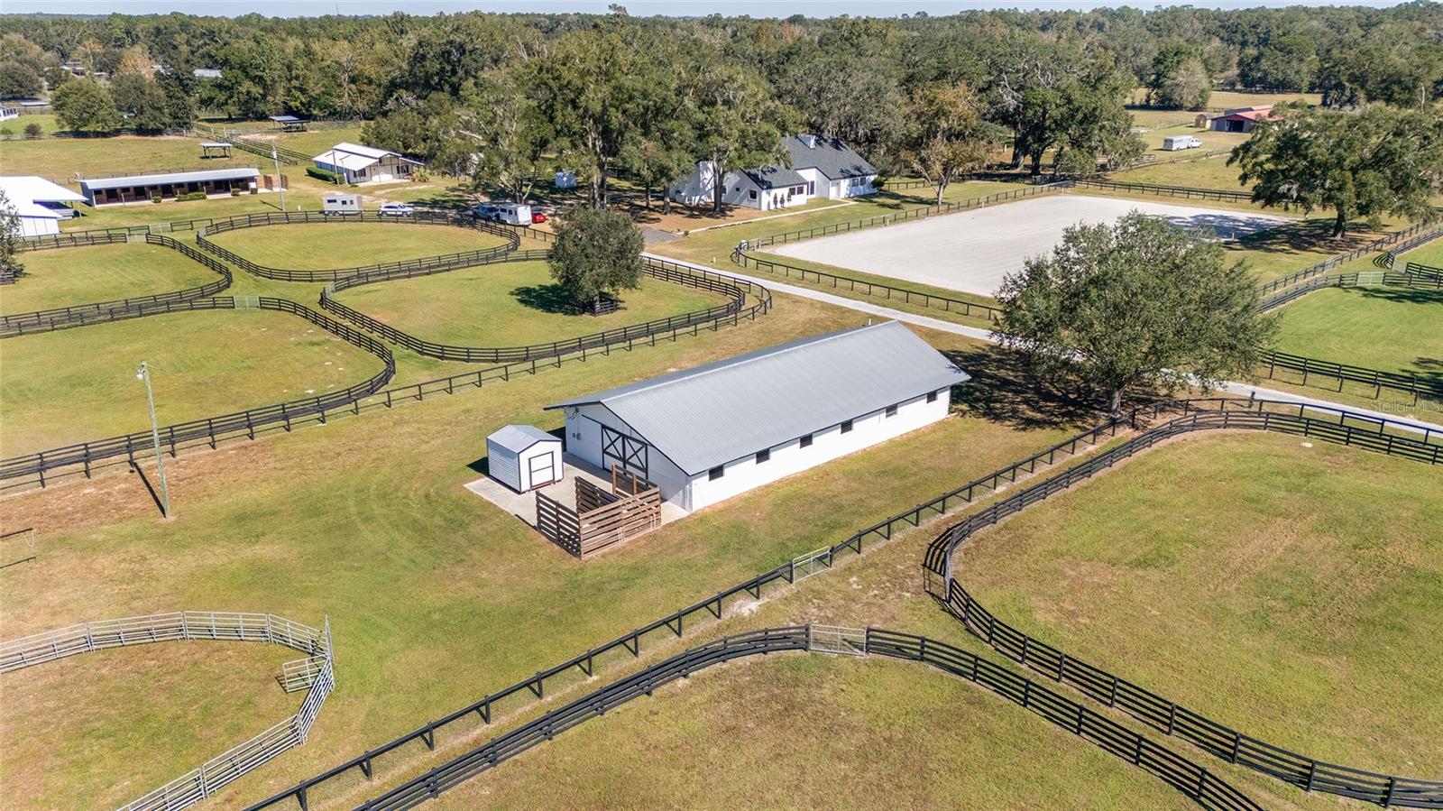 Incredible Price with possibilities of owner financing to qualified buyers.  Welcome to Paradise Farm, a newly renovated
modern 4 bedroom, 4.5 bath, modern farmhouse, thoughtfully designed with expansive windows that fill the home with natural light, allowing for panoramic views of the farm. The soaring vaulted ceilings and open-plan living area create an inviting atmosphere, highlighted by a dramatic stone fireplace, charming wood beams, and stunning architectural details. The chef-inspired kitchen is perfect for both casual and elegant entertaining, featuring granite countertops, double ovens, and custom cabinetry. The owner's suite is a true retreat, offering a spacious layout, dual sinks, a soaking tub, and custom his-and-her closets. The guest suite provides a full bath, walk-in closet, and direct access to the outdoors, ensuring comfort and privacy for your guests. Whether sipping your morning coffee on the north-facing patio or relaxing in the evening, you’ll enjoy beautiful views of your horses grazing in the paddocks, surrounded by the mature oak trees that enhance the property’s natural beauty. The estate includes three fully renovated bedrooms, each with ensuite bathrooms, offering exceptional accommodation for family and guests. 
The TV room provides a tranquil retreat, where you can unwind while looking out over the gorgeous live oaks, thoughtfully illuminated in the evening for a stunning effect.  Check out the video here    https://www.youtube.com/watch?v=LDjXMmpWfdo
The farm's three fully renovated barns including a 10 stall center-aisle concrete block barn with Feed room and tack room with a 1/2 bath.  Additionally, there's a spacious washrack in the back, RV hookup with electric/septic/water.  As well there's charming four- over-sized stall barn complete with a rider’s lounge and laundry facilities and washrack. Additionally, there's a 5 stall shedrow barn with a washrack and a single stallion stall with it's own "high-fenced" paddock area. There are 17 paddocks are well positioned with brand new double fence, wide aisles and water to every paddock. The brand new GGT footing arena includes a 5 inch well to ensure the arena is maintained.  
Additionally, a 3-bedroom, 2-bathroom mobile home offers convenient accommodation for staff or guests. The guest house was renovated and move-in ready. There's plenty of space for your farm equipment in the workshop.  
Paradise Farm offers an optimal environment for horse care, helping to promote strong, healthy bones. The equine infrastructure in Marion County is unparalleled, with easy access to feed stores, tack shops, veterinarians, farriers, showing opportunities, nearby trail riding in the forest, and alternative health care providers. Conveniently located just two minutes from the World Equestrian Center and the WEC UF Veterinarian Center, Paradise Farm offers the perfect blend of luxury living and equine excellence. Whether you're an avid equestrian or simply seeking a stunning private estate, this property is your ideal sanctuary.
Don't miss out on this beautiful farm, ready for you in the 2025 show season. Possible owner financing to qualified buyers.