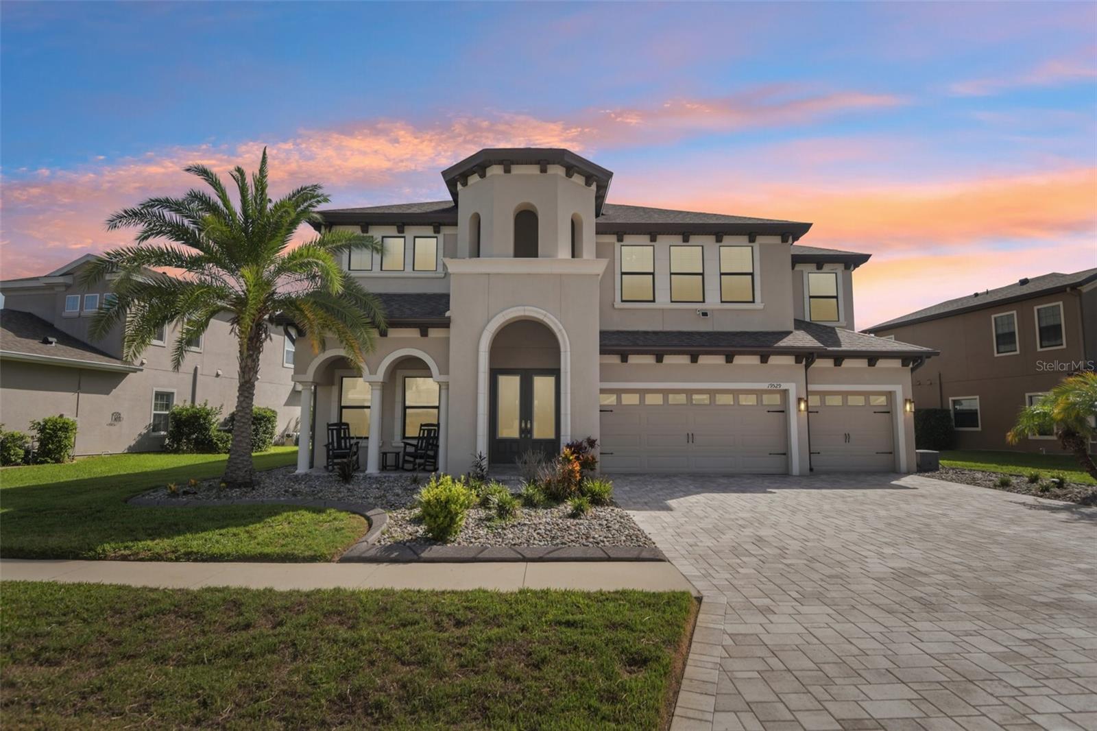 Two primary suites. One on each floor. Both full size, both en suite.
Built in 2018 in Lakeshore Ranch, Land O' Lakes, Florida, this two-story home offers 5 bedrooms, 5 full baths, a 3-car garage, and a true main-level in-law suite with a private en suite bath and walk-in closet, plus a second primary suite upstairs of larger size. Not in a flood zone. This is real multi-generational separation, not a converted den with a daybed.
The main-level primary suite features a tray ceiling, walk-in closet, and en suite bath with a garden tub, separate glass-enclosed shower, and dual-sink vanity. The second-floor primary matches it in scale and adds a custom closet system with a center island plus French doors opening to a private screened balcony overlooking the pond. Every bedroom has a walk-in closet. Bedrooms four and five share a Jack-and-Jill bath with a granite dual vanity.
The kitchen anchors the open-concept main level: quartz countertops, a full island with pendant lighting and seating, stainless appliances including a built-in wall oven and gas cooktop with vented hood, glass tile backsplash, walk-in pantry, and white shaker cabinetry. Wood-look plank tile runs continuously through the main level, so the kitchen, great room, and casual dining read as one space. A stone-accent electric fireplace wall centers the great room. A front flex room serves as gym or a home office. Upstairs, a large loft creates a second living zone.
The laundry room is a designed room, not an afterthought: custom cabinetry, brass hardware, marble-veined counters, deep basin sink, and natural light.
Out back, a screened covered lanai and fenced yard overlook a pond with no rear neighbors, on a .24-acre lot with low-maintenance outdoor space. Paver driveway. Three-car garage. Dual-zone central air, 2018 construction, and a 2018 roof mean newer-build systems throughout nearly 4,900 square feet.
Zoned for Land O' Lakes High School. CDD is included in the annual tax bill.
Lakeshore Ranch is a 24-hour guard-gated community in Land O' Lakes, Pasco County, offering a clubhouse, fitness center, community pools, tennis courts, basketball courts, and a dog park. Minutes from the Suncoast Parkway, SR-54, Tampa Premium Outlets, and the Land O' Lakes Recreation Complex, with quick access to Wiregrass Mall, I-75, and Tampa International Airport.
Move-in ready. Floor plans, 3D tour, and full photo set available. Schedule your showing in Lakeshore Ranch.