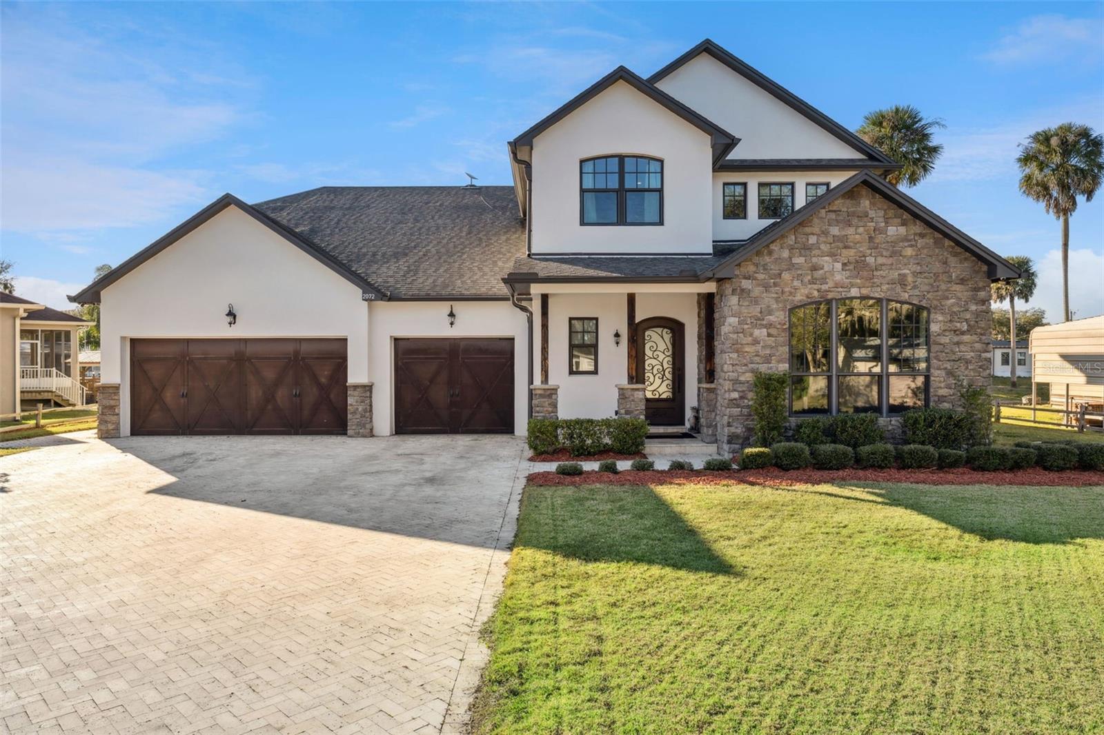 Ask about a lender provided RATE BUY-DOWN CREDIT on this home! **WELCOME HOME** In the perfect location, on an oversized lot, set on a private DEEP-WATER CANAL in the sought-after Palm Shadows community, this exceptional CUSTOM BUILT ESTATE redefines WATERFRONT LIVING with uncompromising craftsmanship, thoughtful design, and DIRECT ACCESS TO THE ST. JOHNS RIVER – all with NO HOA! Major upgrades and infrastructure highlights include a NEW SEAWALL & BOARDWALK (2022), FoxBlock insulated concrete construction with spray foam insulation throughout, a WHOLE HOME GENERAC GENERATOR with a 500-gallon propane tank capable of powering the home for weeks, hurricane-impact doors and windows, two TANKLESS WATER HEATERS, a 3-tank aerobic septic system, Starlink connectivity, and impressively low utility costs for a home of this caliber. Designed to be FULLY SELF CONTAINED, this property delivers both peace of mind and long-term efficiency. From the moment you arrive, the curb appeal makes a statement with a herringbone pattern paver driveway, architectural detailing, stone accents, and an oversized 3-CAR GARAGE. Inside, warmth and character take center stage with 100+ year-old RECLAIMED BARN WOOD FLOORS, exposed WOOD BEAMS, pine tongue-and-groove ceilings, and custom barn doors – timeless elements that elevate every room. The heart of the home is the chef’s dream kitchen, where modern function meets classic style. Two-tone cabinetry feels fresh and modern, the cabinetry extends to the ceiling, and is paired with sleek granite countertops, designer hardware, statement pendant lighting, and a large ISLAND with wrap-around bar seating. Top-of-the-line WOLF APPLIANCES, a built-in DOUBLE WALL OVEN, GAS RANGE, SUB-ZERO REFRIGERATOR, and a butler’s pantry make this space ideal for both everyday living and entertaining. The kitchen flows effortlessly into the casual dining area and light-filled living room, highlighted by a gas FIREPLACE and a wall of folding glass doors for the ultimate indoor/outdoor living experience. The MAIN FLOOR PRIMARY SUITE is positioned to be your private oasis, offering tranquil water views and a spa-inspired en-suite bath revealed through a custom barn door. Marble floors, a soaking tub, seamless glass walk-in shower, dual vanities with a dedicated makeup space, generous storage, and natural light create a true retreat. Custom wood doors lead to the walk-in closet, completing the suite. Upstairs, a spacious BONUS/LOFT area provides flexible living space for a media room, office, or lounge. Two bedrooms share a Jack-and-Jill bath, while a third enjoys its own private en-suite – perfect for guests or multi-generational living. Outdoor living is equally impressive, featuring a TRAVERTINE TILED LANAI, custom OUTDOOR KITCHEN, and a private canal setting ideal for boating, fishing, and relaxing. Launch directly into the canal and head to the St. Johns River to embrace a lifestyle centered around the water. Additional features of this home include Kohler plumbing fixtures, a whole-home VACUUM SYSTEM, dedicated IT/security closet with full wiring and whole-home audio, and even a PRX weight bench in the garage – every detail has been thoughtfully curated! Set within the small-town charm of Geneva, with TOP-RATED SCHOOLS and convenient access to shopping, dining, and daily essentials, this Palm Shadows estate offers the rare blend of privacy, durability, and refined waterfront living. Call today to schedule a tour!