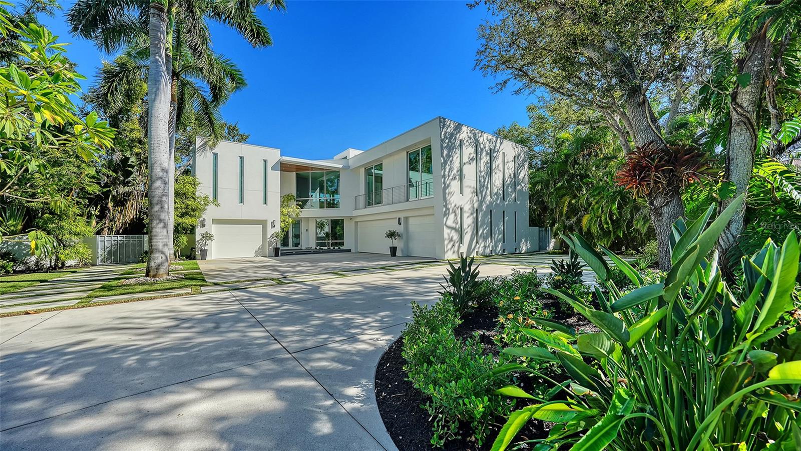 This award-winning Modernist home was designed to provide privacy while maintaining direct tranquil water views framed by mature tropical landscaping. In the desired and private lot enclave of Cedar Park, one approaches the residence via a canopied private lane before entering the ideal spot for boaters, car enthusiasts, or those who just enjoy the serenity of the .6-acre grounds with plus/minus 350 feet of frontage on Cocoanut Bayou. The car enthusiast will appreciate the twin garages accommodating five cars, while boaters will be impressed by the water depth of plus/minus 4 feet, substantial IPE wood dock with 10,000-pound and 7,000-pound lifts, and immediate access to the Bay and Gulf. Designed with practicality and easy living in mind, the light-filled rooms feature high ceilings, wall-to-wall stacking glass doors, a chef’s kitchen with Miele appliances and Italian cabinetry, elevator, a generator, and an open concept plan that  incorporates nearly 900 sq ft of non-conforming space in the most ingenious fashion, and transitions seamlessly between indoor and outdoor living spaces. Enjoy outdoor dining and relaxing on the expansive covered terrace, lounge by the private 40-foot saltwater pool with spa or just drink in the tranquility offered by this special property. The split plan with four bedrooms (one makes an ideal office) and 3½ baths allows for flexibility of use and manageable size. Private, gated beach access is available. This is the ideal home base to enjoy island lifestyle and for you and yours to take advantage of all Sarasota and Siesta offer. Set out by land or sea to enjoy the world-renowned sugar sand beaches, downtown cultural venues, museums, multiple restaurants and shopping. An exceptional opportunity for the discerning.