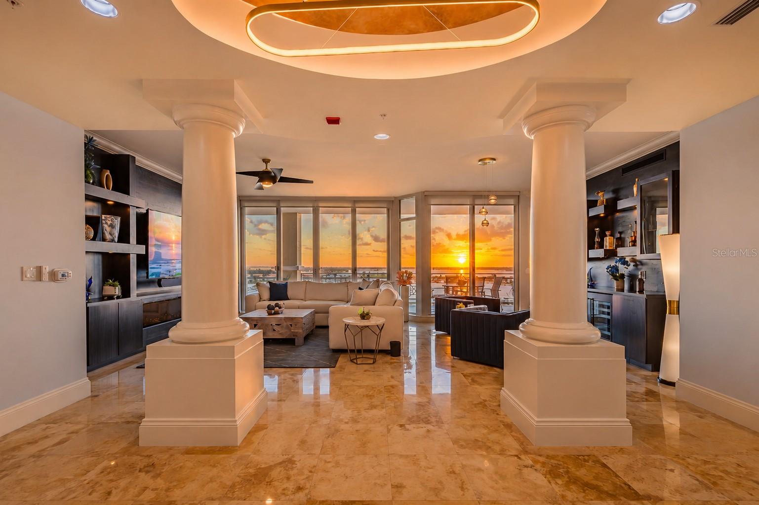 Welcome to one of Bel Mare’s most beautifully updated residences; this exceptional end-unit Rapallo floor plan offers over 3,350 total square feet and captures SWEEPING WATER VIEWS in multiple directions. Enjoy sunrises over the Manatee River and Riviera Dunes Marina from the east-facing balconies, along with stunning sunset views to the west; a rare and highly desirable combination.

Arrive via your PRIVATE ELEVATOR entrance into a refined, open-concept living space featuring polished travertine flooring, professionally painted tray ceilings, and upgraded lighting throughout. The living area showcases CUSTOM built-ins and a FIREPLACE feature wall, while a beautifully designed bar with two beverage/wine refrigerators creates the perfect setting for entertaining.

The kitchen offers Merillat wood cabinetry, stone countertops, a porcelain backsplash, pull-out shelving, and a 6-burner gas cooktop; a rare feature within the community.

The split floor plan provides privacy, with a spacious primary suite offering balcony access, dual walk-in closets, and a fully reimagined SPA-LIKE bath with stunning BRAZILIAN QUARTZ countertops with under counter lighting, LED mirrors, and a custom frameless shower with body sprayers.

Two additional guest suites feature COMPLETELY REMODELED en-suite bathrooms and walk-in closets, while the den; with closet and balcony access, functions as a fourth bedroom or office.

Offered TURNKEY FURNISHED, with each piece professionally curated, this residence is truly move-in ready. The property also includes THREE under-building PARKING SPACES, two of which are side-by-side; a rare and valuable feature.

Bel Mare residents enjoy resort-style amenities, including pools, fitness center, pickleball, theater, social spaces, and guest suites for visiting family and friends, along with access to the Riviera Dunes Beach Club, offering an additional waterfront lifestyle experience included with ownership.

Conveniently located near downtown Bradenton, Anna Maria Island, Sarasota, St. Petersburg, Tampa, and Lakewood Ranch, this location offers both accessibility and coastal living.

A rare opportunity to own a luxury waterfront residence with expansive views, private elevator access, and EXCEPTIONAL UPGRADES throughout.