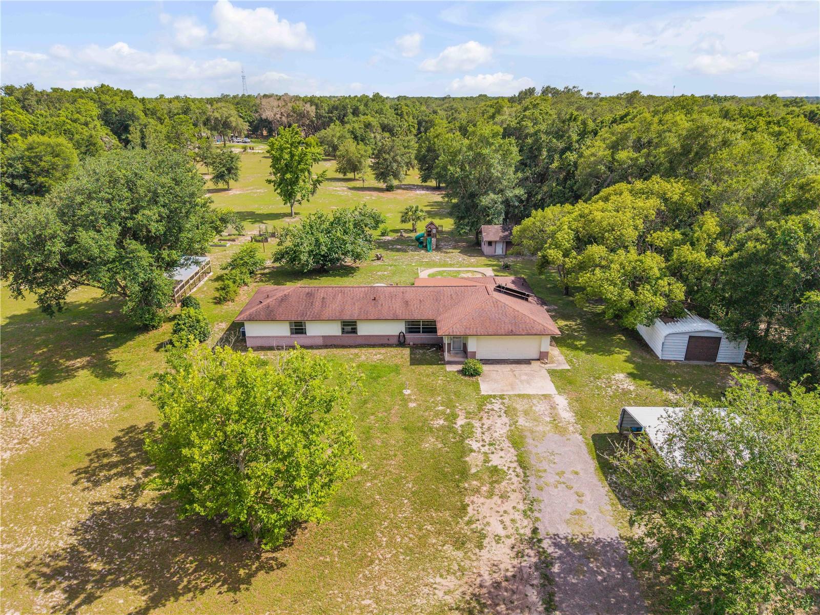 Room to Grow, Work, and Live Well

Trade tight spaces for the freedom of 5+ cleared acres in DeLeon Springs, where modern comfort meets practical country living. Mornings feel different here—quiet land, mature mulberry trees, avocado, pecan, and awapuhi ginger already rooted into the property, plus a serious chicken setup with a 10x10 coop and 16x30 run ready for fresh eggs and hobby-farm dreams.

Inside, the 4-bedroom, 3-bath layout offers flexibility for work, guests, projects, or simply room to spread out. The oversized primary suite creates a true retreat, while the remodeled kitchen brings everyday function and style together with quartz countertops and all-new Samsung appliances. Hard surface flooring throughout means no carpet, and the electric fireplace adds an easy touch of warmth and ambiance.

The big-ticket upgrades make this property even more compelling: a new 30x40 detached metal garage valued at $70,000, newly replaced drain field, whole-house water softener, and generator hookup for added peace of mind.

Properties with this much usable land, infrastructure, and recent investment are not easy to duplicate. Schedule your private showing and come see what life with more space can look like.