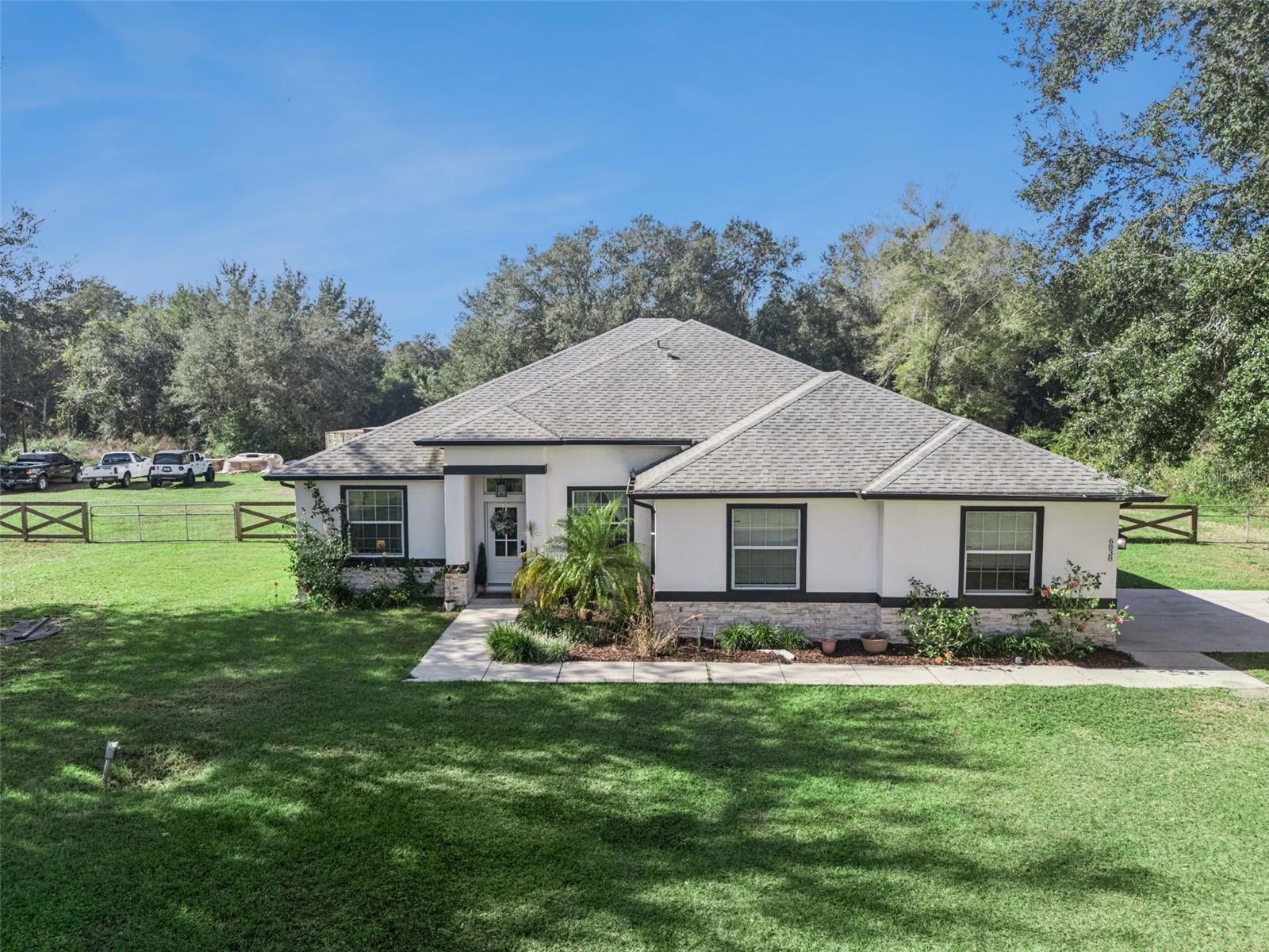 Welcome home to this beautifully maintained 4-bedroom, 2.5-bath property, built in 2018 and perfectly set on 2.2 fully fenced acres for ultimate privacy and space. This property offers the ideal blend of comfort, function, and exceptional outdoor living. Step inside to a bright, open floor plan featuring wood-look tile flooring throughout the main living areas. The heart of the home is the stunning kitchen, complete with a large island, quartz countertops, stainless steel appliances, and plenty of storage—perfect for cooking, entertaining, and gathering with family and friends. The spacious master retreat includes a tray ceiling, new carpet, his-and-hers closets, and an en-suite bathroom with a soaking tub and separate shower. Outdoors, this property truly shines. A 40x60 pole barn (2022) with 14 ft eaves, 50-amp power, and water hookup provides exceptional storage for your RV, boat, or recreational toys. You’ll also find a 30x30 workshop (2020) with 10 ft roll-up doors and its own 50-amp connection—ideal for projects, hobbies, or extra parking. Enjoy the ambiance of outdoor living with a custom 2023 patio, perfect for entertaining, grilling, or relaxing by the fire pit. Additional exterior features include a storage container, covered parking with a concrete slab, and a dedicated garden area ready for growing your own vegetables. Surrounded by peace and privacy yet just minutes from major retailers and I-75, this property offers the best of both worlds—quiet country living with everyday convenience. Don’t miss the chance to own this unique and versatile property!