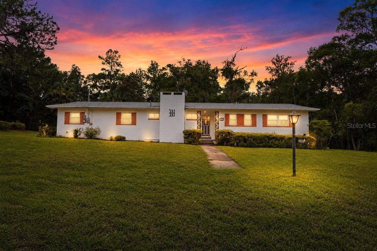 Under contract-accepting backup offers. One or more photo(s) has been virtually staged. According to the City of High Springs, this unique 2+ acre property may be eligible to be divided into two additional buildable lots—creating an exceptional opportunity for future development, multi-generational living, or added investment value. Discover the perfect combination of space, location, and potential with this solid concrete block home situated on over 2 beautiful acres within the city limits of High Springs.
Positioned on a picturesque corner lot shaded by mature fruit trees, this property offers a peaceful, private setting while keeping you just moments from all the conveniences of town. Best of all, there are no HOA fees and no deed restrictions, providing the freedom and flexibility to truly make the property your own. Inside, you'll find three bedrooms, two bathrooms, two spacious living areas, and a large screened-in porch—perfect for relaxing, entertaining, and enjoying Florida's year-round outdoor lifestyle. A covered carport provides convenient parking, while the expansive acreage offers endless possibilities for gardening, recreation, workshops, storage for boats and RVs, animals, or future improvements. Beyond the home itself, the property's development potential is what truly sets it apart. With the possibility of creating two additional buildable lots, buyers have a rare chance to enjoy immediate use of the property while also benefiting from future growth and investment opportunities. Enjoy an active lifestyle in one of High Springs' most desirable in-town locations, with quiet streets ideal for walking and biking. You'll love being within walking distance of charming downtown High Springs, local restaurants, boutiques, parks, and High Springs Community School. Outdoor enthusiasts will appreciate being just minutes from the area's world-famous natural springs, the scenic Santa Fe River, and nearby state parks offering endless opportunities for boating, kayaking, swimming, hiking, and fishing. Conveniently located with easy access to Gainesville and Lake City, this property offers the perfect balance of small-town charm and modern convenience, with shopping, healthcare, and the University of Florida all within easy reach. Properties offering over 2 acres within city limits, no HOA, no deed restrictions, potential lot split opportunities, and a prime location are exceptionally rare. Whether you're looking for a place to call home, a long-term investment, or a property with room to grow, this one-of-a-kind High Springs opportunity is packed with potential. Don't miss your chance to own a property where lifestyle, flexibility, and future possibilities come together.