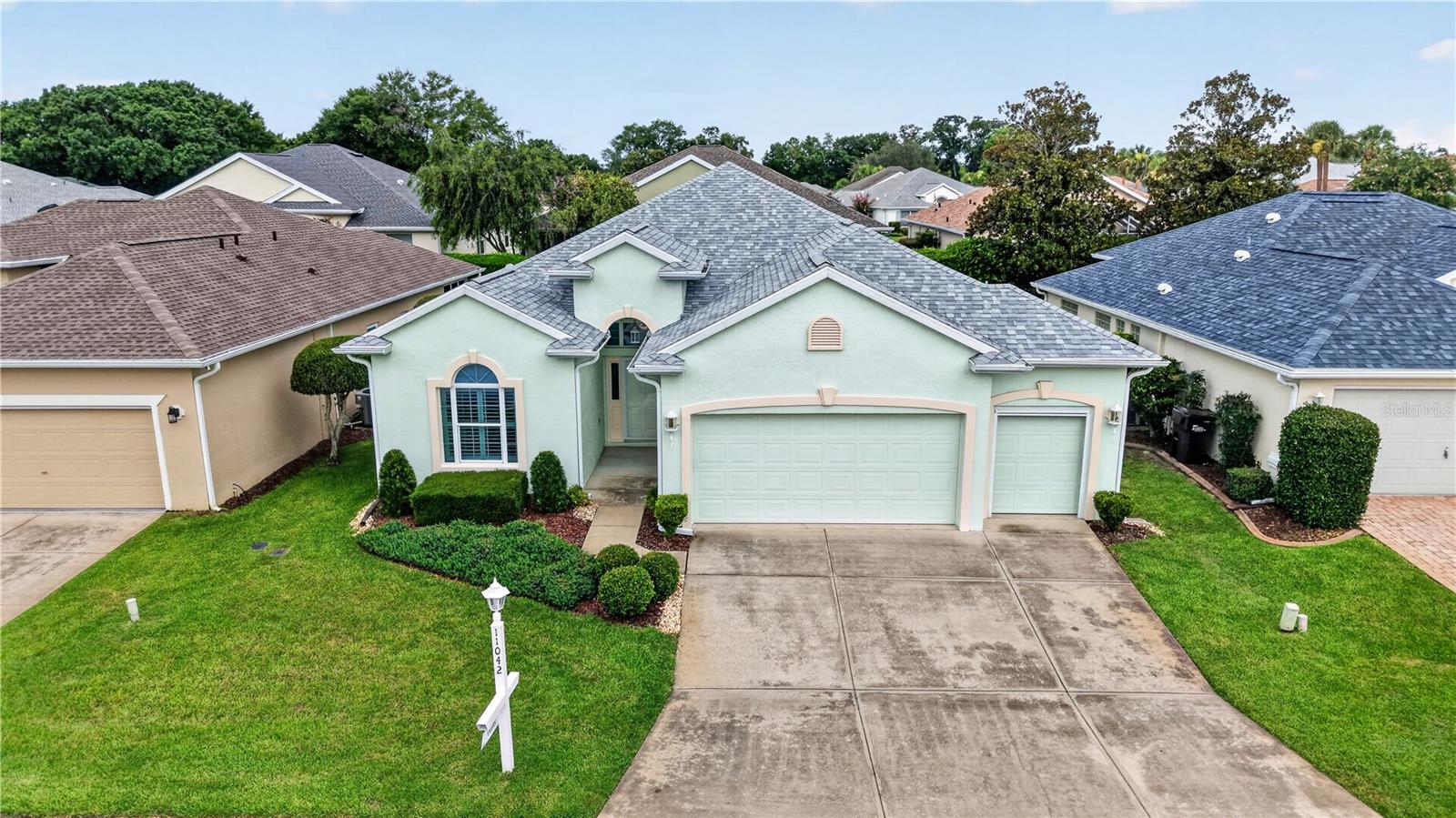 Beautiful Extended Santorini Model in Oak Run!
Welcome home to this beautifully maintained 3-bedroom, 2-bath Extended Santorini offering 1,834 square feet of living space, a 2-car garage plus golf cart garage, and attractive stucco-over-block construction. With a new roof (June 2026) numerous upgrades throughout, this home is move-in ready. 
Step inside to discover soaring vaulted ceilings, abundant natural light, and an open, inviting floor plan designed for comfortable everyday living and entertaining. The spacious living and dining areas flow seamlessly into the well-appointed kitchen featuring Corian countertops, wood cabinetry with pull-out shelving, a breakfast bar, built-in desk, water filtration system, and updated appliances. 
Just beyond the kitchen, enjoy your morning coffee in the bright breakfast nook or relax in the enclosed Florida room, complete with tile flooring, ceiling fan, built-in speakers, and peaceful backyard views. The acrylic-enclosed lanai provides even more flexible living space to enjoy Florida's beautiful weather year-round. 
The spacious primary suite offers tray ceilings, plantation shutters, Dual walk-in closets, and a beautifully appointed en-suite bath featuring a seamless walk-in shower with rain and handheld showerheads, built-in seat, grab bars, and comfort-height vanity and commode. Two additional guest bedrooms and a full guest bath provide plenty of room for family and visitors. 
Additional features include: Central Vacuum, Surround sound and Speakers, Radiant Heat Barrier in the Attic, Inside Laundry Room with fabulous walk in Pantry, and whole house surge protection!!  Golf Cart Garage Door Screen and Utility Sink in the Oversized Garage! 
Located in the highly desirable Oak Run community, the monthly maintained lot fee includes lawn maintenance, shrub trimming, and cable, allowing you to spend more time enjoying the Florida lifestyle. The home is also being offered partially furnished, making your move even easier. Schedule your private showing today! Make sure to watch our Video Attached to listing!
