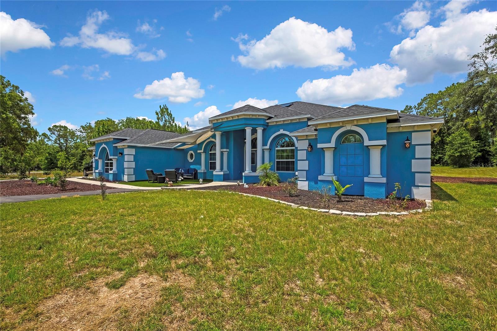 Welcome to this exceptional luxury retreat in the highly sought after Oakwood Acres! This stunning 5 bedroom, 4 bath, cabana zero entry pool home, built in 2023, offers the perfect blend of modern elegance, comfort and privacy on 1.3 Acres on of beautifully appointed property. Step inside to discover a thoughtfully designed open-concept living space featuring soaring ceilings, impressive architectural details, and grand columns that create a true sense of sophistication. The gourmet kitchen showcases rich espresso cabinetry, stainless steel appliances, granite counters and a stylish layout perfect for entertaining family and friends. The spacious split bedroom floor plan provides both privacy and flexibility, while the cabana style seamlessly connects indoor and outdoor living. Step outside to your private oasis featuring a spectacular zero-entry pool, ideal for relaxing, entertaining or enjoying Florida's year round sunshine. unwind after a long hard day in the expansive hot tub. With it's newer construction, expansive acreage, luxurious finishes, and resort-style outdoor living, this estate offers a rare opportunity to own a move in ready dream home in a serene setting.