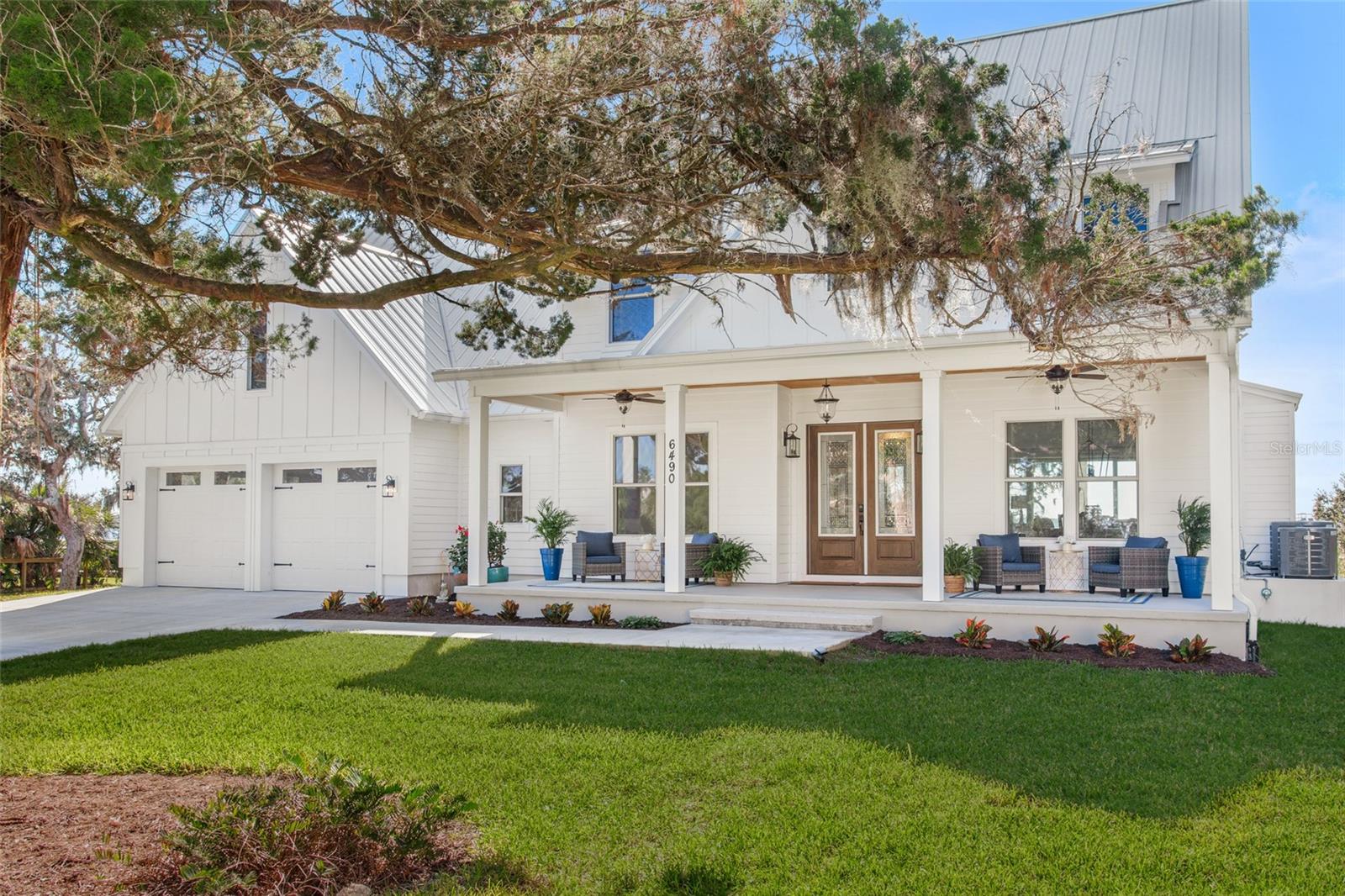 This luxurious coastal home is a true oasis, offering breathtaking views of the Intracoastal Waterway and an array of outdoor living spaces. Nestled on a 2.28-acre property, the gated 5BR/4.5BA residence boasts 150 ft of prime water frontage and private deep water dock access that can accommodate a 57' boat. Newly built, the home offers a serene retreat while still being a stone's throw away from local shops, eateries, and the beach. The home boasts three levels of expansive balconies, taking full advantage of the picturesque views and refreshing breezes. Surrounded by mature oak, cedar and palm trees, the property's wide front porch, complete with rocking chairs, invites you to slow down and soak in the beauty of your surroundings.

Inside, the open living spaces are awash with natural light, designed to enhance the stunning views. The office and dining room, which seamlessly connect with the living room and kitchen, are perfect for both daily living and entertaining. The main gathering room features a 20ft clear-story ceiling, a cozy gas fireplace, custom built-ins and a wall of sliding doors that open to a covered porch - ideal for dining al fresco. The kitchen is a chef's dream, with a blend of white and wood cabinets, creamy quartz countertops and a large central island with seating. High-end appliances include an Electrolux full refrigerator/full freezer, a 6-burner Signature Kitchen Suite range with griddle and double oven, a Bosch dishwasher, and a sink with a view that will make doing the dishes a pleasure. The kitchen also includes a walk-through Butler's pantry with custom shelving and a built-in microwave. The first floor also features a half bath for guests, a utility room, and the luxurious master suite. The master retreat is complete with a vaulted ceiling and magnificent views of the Intracoastal Waterway, while the master bathroom is a true oasis with 24x48 Italian porcelain tiles, split vanities, an oversized shower with dual shower heads, and two walk-in closets. The second floor boasts a guest bedroom with a vaulted ceiling and en-suite bathroom, a spacious 18x12 loft-style family room with a wet bar and beverage fridge, and two additional bedrooms with a shared bath. The second-level covered porch, measuring 33x10, provides the perfect place to enjoy sunsets and stars, and a staircase leads to a 3rd floor 15x10 bonus room and covered balcony. The outdoor areas of this magnificent property offer plenty of opportunities for relaxation, recreation, and entertaining. With room for gardening, games, a bench swing, fire pit, cornhole, dock seating, and more, there's something for everyone. The main house features a two-car garage, and there is an additional detached garage with two parking spots and an apartment above that can be used as a mother in law suite or as you please. A circular drive connects the two structures, and there is a detached shed for extra storage. An on-demand site generator is located away from the main home and out of site. The gated entry ensures privacy, and there is a nearby public beach walkover, inviting you to enjoy the sand and surf…see you there.