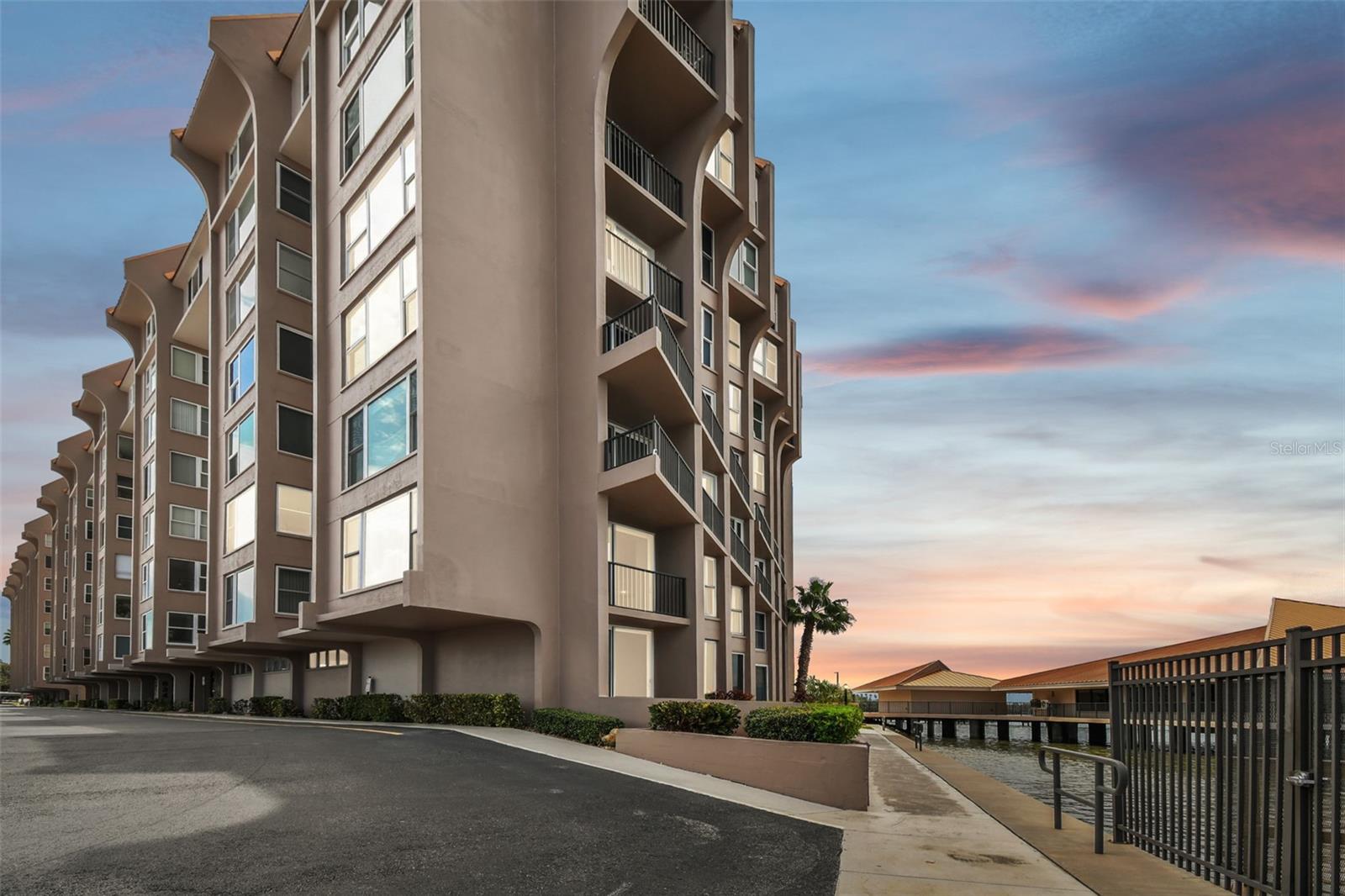 Welcome to your coastal sanctuary in the sought-after 55-plus community of Edgewater Arms, where breathtaking waterfront views meet modern luxury. This beautifully renovated condominium, completely updated in 2015, showcases a blend of style, comfort and durability, with impact windows throughout for peace of mind. Go inside to unobstructed vistas stretching to Caladesi Island and beyond. The expansive living room, featuring an electric fireplace and custom-built entertainment bar with wine cooler, is ideal for relaxing or entertaining. Glass sliders lead to your private balcony, where sea breezes and stunning sunsets become part of your everyday life. The kitchen flows seamlessly into the dining area and offers a large walk-in pantry for all your culinary needs. The primary suite is a retreat, with a spa-like bath, dual vanities and a spacious walk-in closet. Two additional bedrooms and a full guest bath provide comfort for family or friends, while the in-unit washer and dryer make everyday living easy. Edgewater Arms offers an array of amenities designed for leisure and connection, such as heated waterfront pool, kayak launch, shuffleboard courts, ping pong and billiards, and a tiki hut with a gas grill for social gatherings by the water. Enjoy sunsets from the serene waterfront park or visit downtown Dunedin, with its restaurants, cafes, breweries, live music, art festivals and more. Just minutes from Dunedin Marina, Honeymoon Island beaches and the Toronto Blue Jays spring training ballpark, this location combines an active lifestyle with peaceful coastal living.