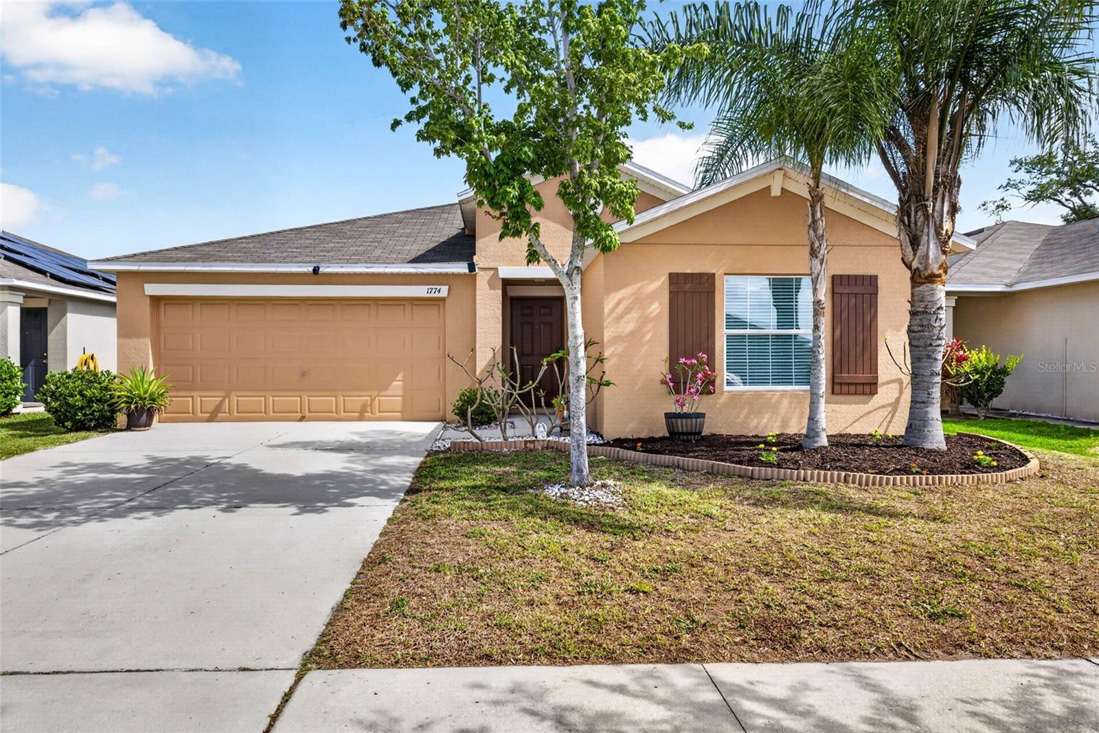 Welcome Home!!! USDA ELIGIBLE FINANCING FOR QUALIFIED BUYERS!!! Step into comfort and convenience with this beautifully designed (freshly painted exterior 2025) 4-bedroom, 2-bathroom home featuring a 2-car garage and a large, fully fenced backyard with pavered patio—perfect for relaxing and/or entertaining year round in Florida. The wide-open floor plan creates a seamless flow between the kitchen, dining, and main living areas, all filled with natural light from oversized picture windows and sliding glass doors that lead to a pavered back patio and fully fenced back yard. The kitchen overlooks the main living space, making it ideal for gatherings, and comes fully equipped with all appliances, including a refrigerator (2026) and stove (2025). A dedicated dining area sits just off the kitchen, offering both functionality and style with views of the back yard through sliding glass doors. Tiled flooring runs throughout the main traffic areas, while the primary bedroom boasts luxury vinyl plank flooring for a modern touch. Secondary bedrooms are comfortably carpeted and thoughtfully positioned at the front of the home, sharing a full bathroom—ideal for family or guests. Ceiling fans are installed in all bedrooms and the main living area for added comfort. The spacious primary suite is located in the back of the home and offers a private en suite bathroom, complete with dual sinks, a walk-in shower, private water closet, and a large walk-in closet conveniently located just off the bathroom. Enjoy the ease of move-in ready living with washer and dryer included, plus a location that puts you just minutes from shopping, beaches, and major highways—keeping everything you need within reach. This home blends style, function, and location—schedule your private showing today!