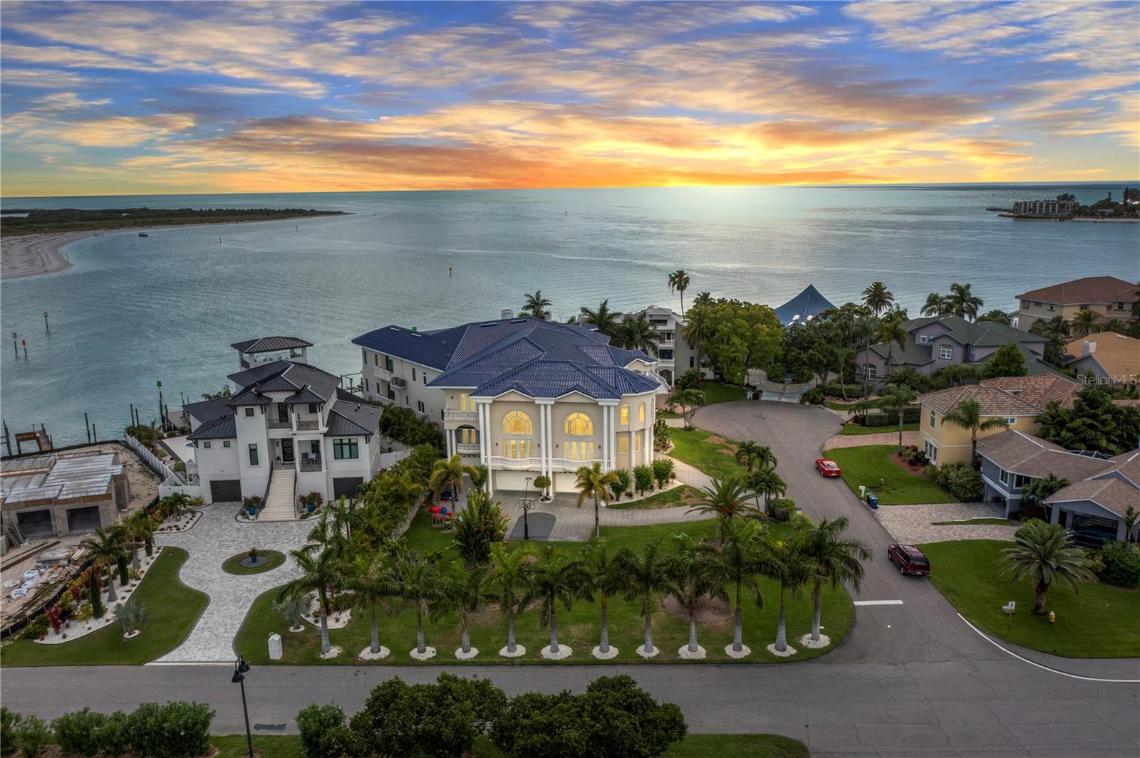 A rare waterfront masterpiece offering unparalleled luxury, privacy, and breathtaking panoramic views of the Gulf. Constructed entirely of solid block and poured concrete across all three levels, this exceptional estate is ideally positioned on a coveted double lot with over 88 feet of pristine water frontage—delivering unobstructed, open-water sunsets across Tampa Bay.
Spanning over 25,000 square feet under roof, this architecturally refined residence showcases six expansive bedroom suites, each thoughtfully designed with custom walk-in wardrobes and spa-inspired en-suite baths. The chef’s kitchen is a true statement, adorned with exotic emerald granite countertops and backsplash, dual sinks, professional-grade gas range, and top-tier luxury appliances. An additional entertainer’s kitchen—complete with matte black marble finishes, butler’s pantry, and wine refrigeration—elevates hosting to an art form.
The grand formal living space is anchored by a dramatic floor-to-ceiling fireplace and seamlessly transitions through expansive sliders to a second-level waterfront lounge deck—perfectly capturing the home’s effortless indoor-outdoor lifestyle. Throughout the residence, meticulous craftsmanship is evident in tray ceilings with custom wood inlays and intricate crown molding, 
The primary retreat is a private sanctuary featuring an opulent dressing room with bespoke cabinetry and glass display showcases. Dual spa-like primary bathrooms offer water closets, oversized vanities, soaking tubs, and frameless glass showers—designed for ultimate comfort and indulgence.
For the boating enthusiast, this property delivers deep water access with no fixed bridges, providing seamless passage to the Gulf. The newly updated seawall and expansive dock with lift accommodate luxury vessels with ease. An impressive 8-car garage with dedicated workshop space ensures ample room for vehicles, toys, and storage.
Located just minutes from world-renowned beaches and less than 35 minutes to Tampa International Airport, this extraordinary residence offers the perfect blend of refined coastal living and convenience.
This is more than a home; it is a statement of lifestyle, design, and waterfront excellence.
