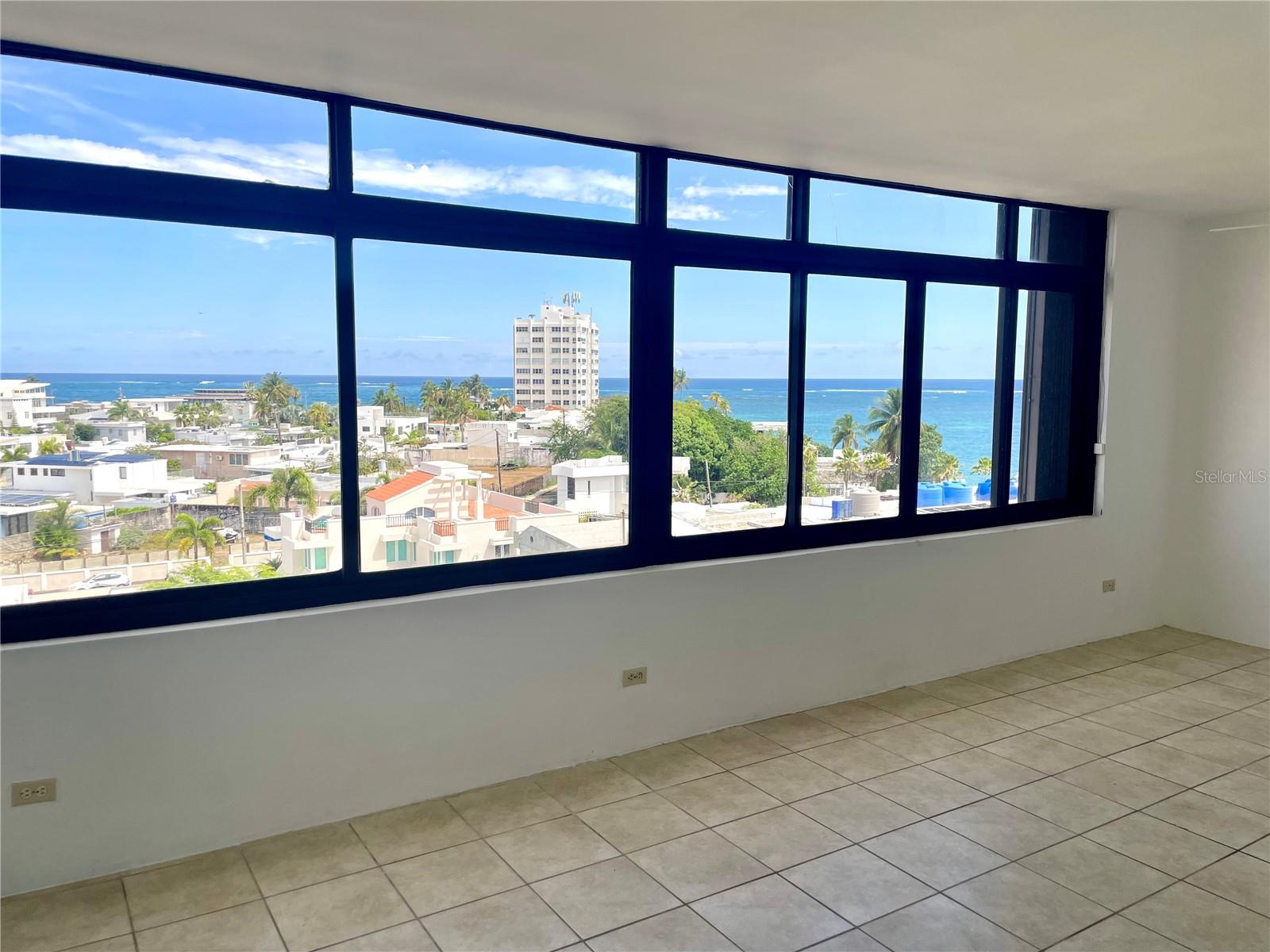 Enjoy this beautiful ocean view from living , dining , kitchen and bedroom and experience to live close to the ocean,  but in an exclusive and quiet area. One of a kind apartment consisting of very spacious one bedroom and one bathroom. Is a corner apartment of 828 square feet that was completely reorganized and changed inside and has a big opened kitchen completely equipped.  The building is located in San Juan in front of the Atlantic Ocean with boundary to Isla Verde, Carolina very close to restaurants,  Isla Verde beach, supermarkets, pharmacy among other important places. It has controlled access all the time and security at nights and weekends. It also has BBQ area and a residents community patio. The apartment includes one  assigned parking space.  Short term rentals are not allowed Must see!!