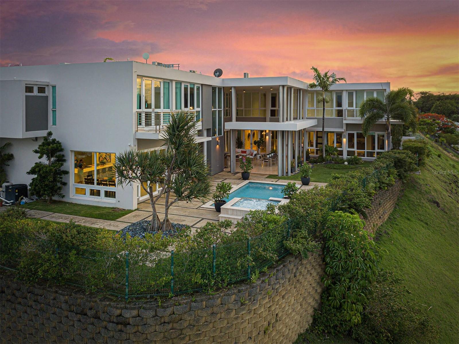 Experience high-altitude living in this stunning Guaynabo residence with breathtaking city and mountain views. Spanning under 10,000 square feet, this expansive home offers unparalleled luxury and features.

Step into this grand home with high ceilings, creating an airy atmosphere. With 7 bedrooms and 6.5 bathrooms, it's perfect for large families or hosting guests. The chef's dream kitchen includes induction stove, and two dishwashers for convenience. A comprehensive security system ensures safety, with cameras inside and outside.

The bedrooms feature built-in desks for studying or creativity. Every bedroom has spacious walk-in closets. Each floor has its own washer and dryer. A spacious maid's room with a bathroom in the first floor for staff or guests. Other highlights include a craft room, sitting room/office, library, and wine cellar.

An attached bonus room with a walk-in closet and full bathroom adds versatility. Formal dining and living rooms create an elegant setting, while the informal dining room and family room offer a cozy atmosphere. Abundant storage spaces are found throughout the property.

Equipped with a generator and water cistern, the property ensures uninterrupted power and water. Enjoy stunning views from balconies and embrace outdoor living with a covered patio and small outdoor kitchen/serving area.

Residents have access to amenities like a swimming pool, tennis court, basketball court, and covered gazebo area. Safety measures include lockable doors and a two-car garage with driveway parking for 5 cars. The pool spa heater and guard fence allow year-round comfort and safety.

Own this exceptional custom-built home in Guaynabo, where luxury, comfort, and breathtaking views converge. Schedule your private showing today and experience high-altitude living at its finest.