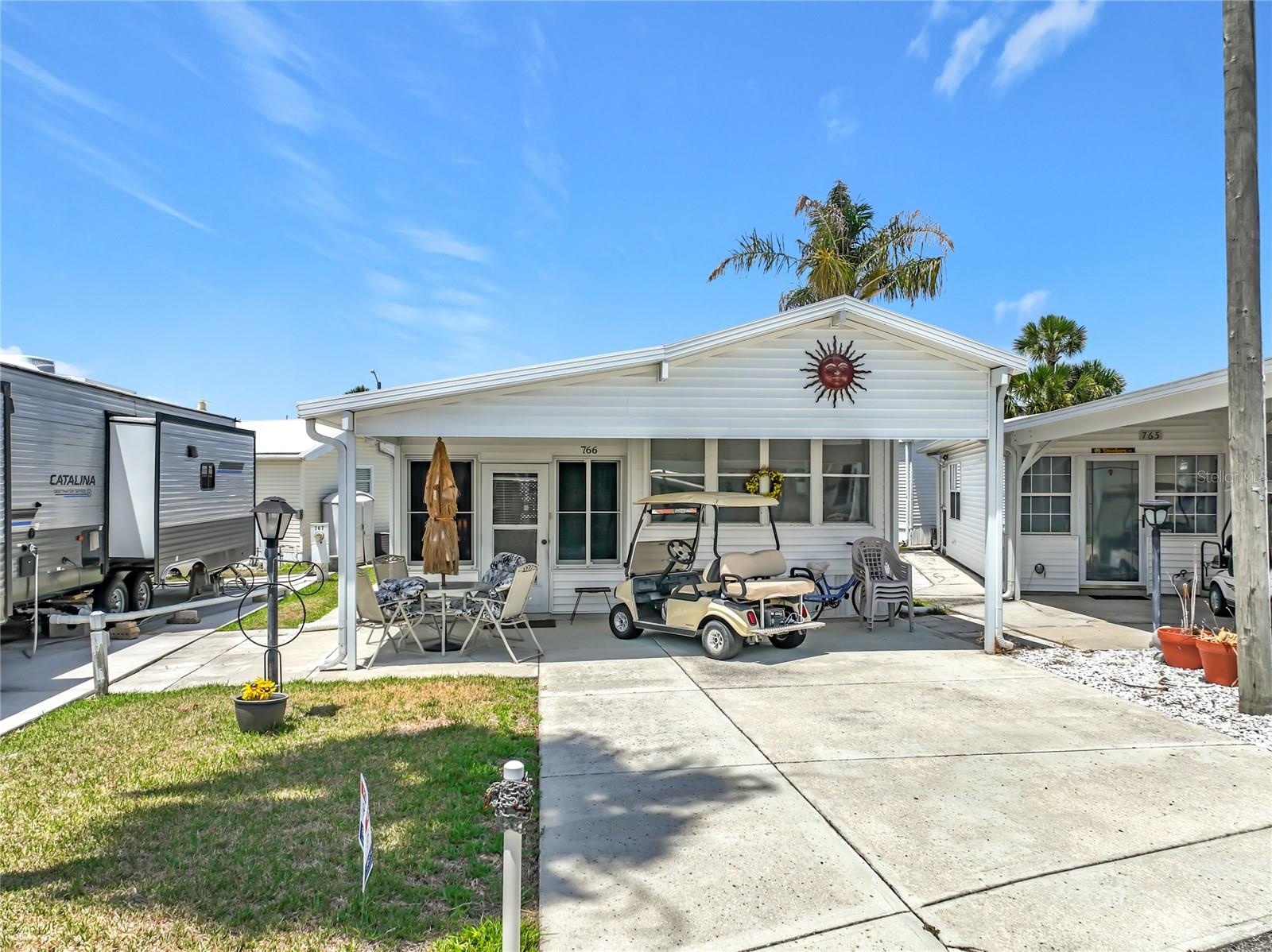 **REDUCED TO SELL - SELLER IS ALSO THROWING IN THEIR GOLF CART! Charming 1-bedroom, 1-bathroom home ideally located just a short distance from one of the community’s pools in the highly sought-after gated lakefront community of Outdoor Resorts at Orlando. This well-maintained property offers comfortable Florida living with several thoughtful upgrades throughout.  The home features a bright Florida room with new sliding windows, creating a versatile space to relax or entertain year-round. Additional highlights include convenient interior stair storage, a 2-car driveway, and a newer carport for added functionality and protection.  A wide side walkway leads to a private rear patio, complete with a patio set and barbecue grill—perfect for enjoying the Florida sunshine or hosting family and friends.  Outdoor Resorts at Orlando offers an exceptional lifestyle with resort-style amenities including two large heated pools, a heated kiddie pool,  playground, lighted tennis courts, pickleball, shuffleboard, a par-3 golf course, mini golf area, volleyball court, basketball court, bocce ball, and horseshoes.  For water enthusiasts, the community provides access to Lake Davenport with a private boat ramp, allowing for boating, jet skiing, water skiing, and fishing. The clubhouse features a library, lounge for socializing or card games, and a spacious auditorium for community events and activities.  This is a fantastic opportunity to enjoy resort-style living in a vibrant, amenity-rich community close to everything Central Florida has to offer.