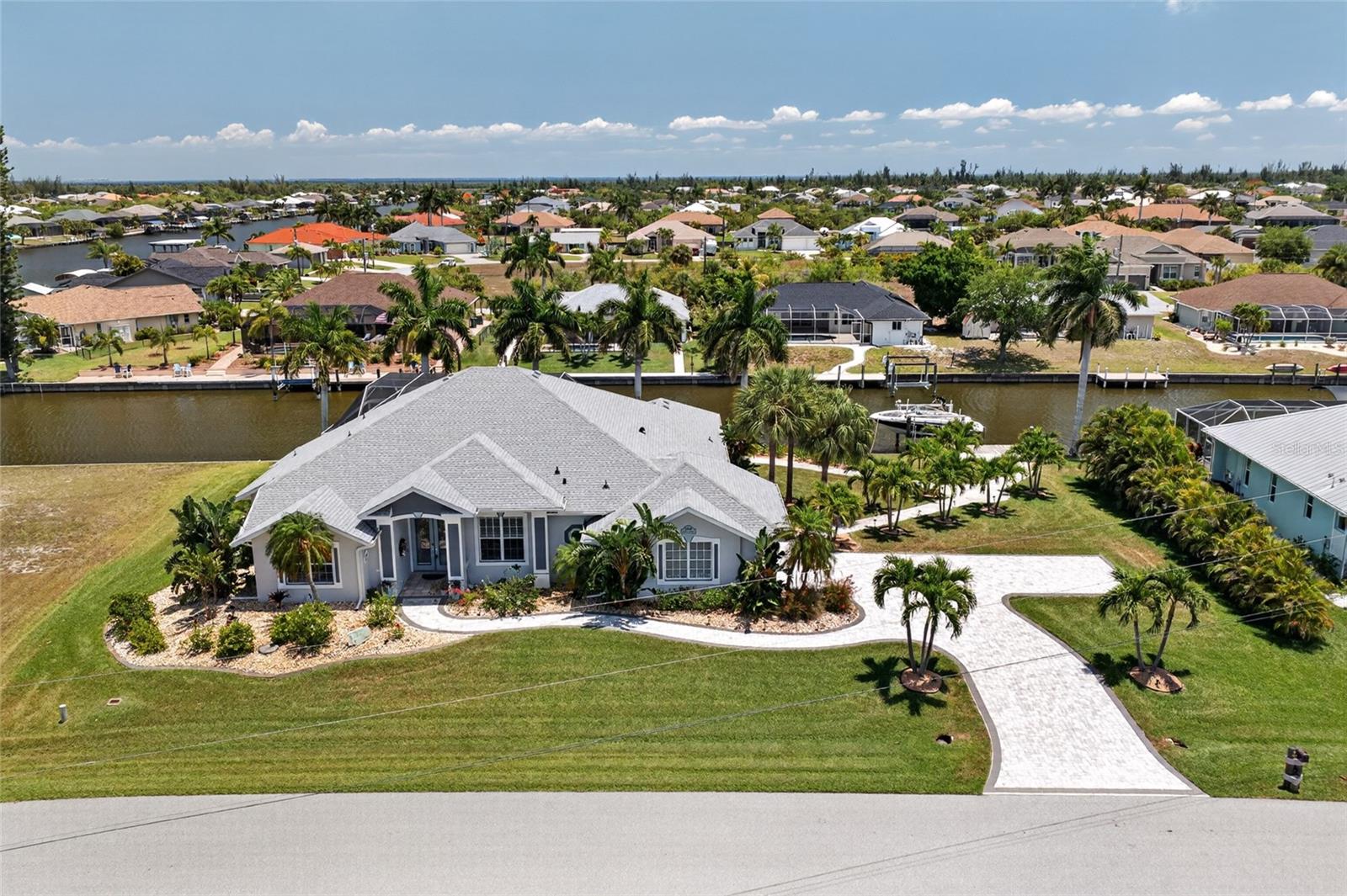 LUXURY WATERFRONT LIVING IN SOUTH GULF COVE WITH STUNNING INTERSECTING CANAL VIEWS and NO FLOOD ZONE! Welcome to this BEAUTIFULLY DESIGNED 4 BEDROOM, 3 BATHROOM, 2 CAR GARAGE POOL & SPA HOME perfectly positioned on an OVERSIZED DOUBLE LOT with approximately 184 FEET OF WATER FRONTAGE along the ROSEBUD WATERWAY. Surrounded by lush tropical landscaping and showcasing breathtaking WIDE WATER VIEWS, this property offers the ultimate blend of elegance, comfort, and the Florida boating lifestyle.

From the moment you step inside, you’re greeted by an OPEN, LIGHT-FILLED FLOORPLAN designed to maximize both space and waterfront scenery. Expansive 90-DEGREE POCKET SLIDERS create a seamless indoor-outdoor living experience, opening the home to the spectacular lanai and pool area while framing picturesque intersecting canal views from multiple living spaces.

Designed for both entertaining and everyday luxury, the home offers multiple gathering areas including a spacious family room highlighted by elegant tray ceiling details and a cozy fireplace that creates a warm, inviting atmosphere. The AQUARIUM GLASS BREAKFAST NOOK provides a stunning backdrop for casual dining while overlooking the sparkling pool and waterways beyond.

The kitchen is beautifully appointed with GRANITE COUNTERTOPS, STAINLESS STEEL APPLIANCES, attractive cabinetry, tiled backsplash, and ample prep space—perfect for hosting family and guests with ease.

The OVERSIZED PRIMARY SUITE serves as a private retreat with direct lanai access, allowing you to wake up to peaceful water views each morning. The SPA-STYLE ENSUITE BATHROOM offers generous space designed for relaxation and comfort. The LARGE WALK IN CLOSET with BUILT IN DRAWERS makes organization effortless. Spacious guest bedrooms provide flexibility for visitors and family, including a thoughtfully designed JACK-AND-JILL BATHROOM setup for added convenience.

Step outside to your private RESORT-STYLE OUTDOOR OASIS featuring a HEATED POOL AND SEPARATELY HEATED SPA—ideal for year-round enjoyment. The expansive lanai and waterfront setting create the perfect place to entertain, unwind, and enjoy Southwest Florida sunsets. Boating enthusiasts will appreciate the LARGE DOCK and 10,000 LB BOAT LIFT installed in 2024, providing effortless access to the Gulf of Mexico and endless waterfront adventures.

Major updates provide peace of mind, including a NEW ROOF (2022), NEW POOL PUMP (2022), and NEW 5-TON A/C SYSTEM (2021).

Located in the highly desirable SOUTH GULF COVE community, this exceptional property is just a short drive to Gulf beaches, golf courses, waterfront dining, shopping, parks, and world-class fishing.

This is more than a home—it’s a WATERFRONT LIFESTYLE EXPERIENCE. Schedule your private showing today and discover everything this extraordinary property has to offer!
