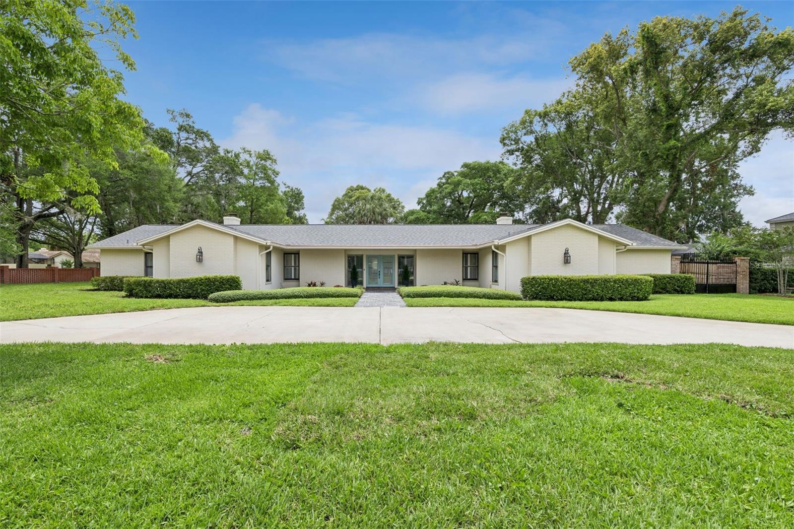 Welcome to Florida living at its finest—where expansive indoor-outdoor design, resort-style amenities, and thoughtful updates come together on an impressive one-story estate. Offering 5 bedrooms, 4.5 bathrooms, a dedicated office, and 4,346 square feet, this beautifully maintained ranch home is designed to maximize space, function, and connection to the outdoors.  From the moment you arrive, the circular driveway creates a grand first impression while the gated side-entry drive provides additional access to the oversized rear-entry garage and extra flexibility for storage and parking.  Designed for true Florida living, the entire home wraps around an extraordinary outdoor oasis. Enjoy a massive pool complete with waterslide and diving area, an expansive pavered decking, and a dedicated full pool bath for convenience. Whether hosting friends, enjoying morning coffee, relaxing with afternoon drinks, floating in your luxurious pool soaking up sunshine, or spending evenings under the stars around the fire pit, this outdoor space was built to be enjoyed year-round.  Inside, engineered hardwood floors flow throughout the main living areas and kitchen, creating warmth and continuity throughout. The spacious living, dining, and kitchen areas all overlook the pool.  The kitchen serves as the heart of the home, featuring gorgeous white cabinetry, stainless steel appliances, sprawling granite countertops, double ovens, and an expansive island with an induction cooktop and oversized breakfast bar seating. A dedicated coffee bar, abundant storage, and generous gathering space make this kitchen as functional as it is inviting.  The private primary suite offers a peaceful retreat with two large walk-in closets, dual vanities, walk-in shower, and sliding glass doors leading directly to the pool area. Additional bedrooms offer flexibility for guests, multigenerational living, hobbies, or fitness space, while the dedicated office provides a quiet work-from-home option.  Additional highlights include: a new roof (2019), new electrical panel (2020), two water heaters replaced in 2020 and 2021, and a pool pump and filter replaced in 2026, offering valuable peace of mind. The home also features a spacious indoor laundry room, abundant storage throughout, and the thoughtful updates today's buyers appreciate.  Located in desirable Spring Valley Gardens, this move-in-ready property combines spacious single-story living with an exceptional indoor-outdoor lifestyle and optional HOA amenities including access to the community ski lake, boat ramp, a lakeside park, a beach volleyball court, basketball court, pickleball courts, tennis courts, a pavilion, and community run activities.  Don’t miss this rare opportunity to enjoy resort-inspired living in the heart of Altamonte Springs.  Call me to schedule your private showing today!