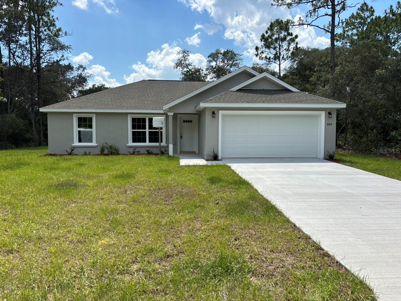 NEW CONSTRUCTION. MOVE-IN READY! The Key West Model in Citrus Springs offers 3 bedrooms, 2 bathrooms, and 1,405 square feet of comfortable living space. Built for lasting value, this home features concrete block construction, a 30-year architectural shingle roof, energy-efficient double-pane windows, and a 10-year structural warranty. Inside, the open, split-bedroom floor plan features vaulted ceilings and luxury vinyl plank flooring throughout. The kitchen includes stainless steel appliances, custom white shaker cabinets with soft-close drawers, granite countertops, and a pantry. Both bathrooms also feature granite countertops for a clean, coordinated finish. Additional features include washer and dryer hookups, a covered patio, sliding glass doors, and an attached 2-car garage with an opener and remotes. Enjoy ownership freedom with no HOA fees, plus a high-and-dry location in Flood Zone X, where flood insurance is not required.