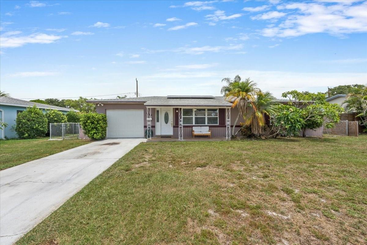 One or more pictures are virtually staged. Welcome to this classic Florida solid block home offering incredible upside potential and the perfect opportunity to build sweat equity with just a few simple improvements! Tucked away in a highly desirable, established neighborhood outside of a flood zone, this 2-bedroom, 2-bathroom property is situated on a generous lot with a spacious lanai and durable laminate flooring throughout. A massive bonus includes the newer roof equipped with fully owned, completely paid-off solar panels for immediate energy savings. The attached 1-car garage maximizes convenience, housing the washer and dryer alongside the home’s second full bathroom. Location is unbeatable, placing you just a couple of blocks from the J.W. Cate Recreation Center and Northwest Park, which features an community pool, athletic fields, tennis courts, a gym, and a dog park. Plus, you are just minutes from Tyrone Mall, local dining, and easy interstate access. With major mechanical upgrades already handled and undeniable room for improvement, this home is a rare find packed with equity-boosting potential!