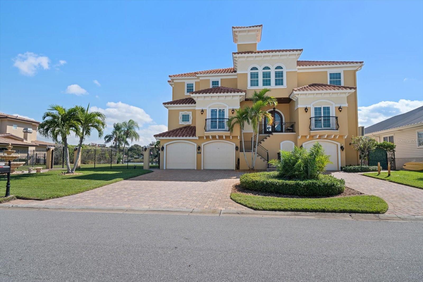 Nestled in the highly coveted Harbor Bluffs community, this Mediterranean-inspired estate exudes grand curb appeal and rests on a rare, almost double lot with tropical landscaping and a pavered circular driveway. Built in 2007, this home meets all hurricane standards and experienced zero water intrusion during last year’s unprecedented flooding, providing peace of mind alongside its luxurious design. Step through the double-door entryway into soaring ceilings and walls of windows and doors that perfectly frame serene water views. The formal living room impresses with wrought-iron accents and chandelier, while the formal dining room, located adjacent to the kitchen, ensures effortless entertaining. At the heart of the home, the spacious dine-in kitchen boasts granite counters, stainless steel appliances, and a large island with seating, all opening to a family room with a cozy fireplace and French doors leading to the pool and outdoor entertaining areas. Enjoy mornings watching dolphins at play from the water-view kitchen, or step outside to relax in your resort-style pool and expansive outdoor spaces, including a beautiful side yard and green space. The primary suite is a luxurious retreat with breathtaking water views, a custom walk-in shower, a soaker tub, two private water closets, ample counter space, and French door access to a covered patio. Additional bedrooms are well-appointed with plentiful closets and water views, while a convenient downstairs guest bedroom offers privacy with its own balcony and access to a full bathroom. Designed for the boating and fishing enthusiast, the property features a covered deep-water slip with 30,000 lb lift and an additional 10,000 lb lift. Additional amenities include a expansive garage, oversized laundry room, and convenient elevator, creating the ultimate combination of comfort, luxury, and functionality. Don’t miss this rare opportunity to own a stunning Harbor Bluffs waterfront estate.
