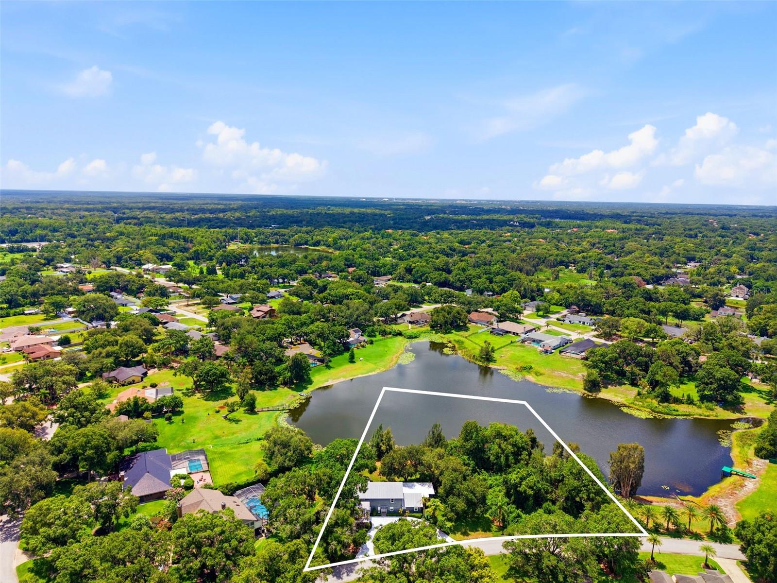 Peaceful LAKEFRONT living, exceptional space, and true PRIDE OF OWNERSHIP come together at 708 Warren Road in Lutz. With its spacious layout, peaceful lakefront setting, oversized lot, no HOA, desirable school zoning, and long list of updates, this home offers a rare combination of comfort, flexibility, and Florida lakefront living in one of Lutz’s most convenient locations. Set within a LUXURY lakefront NEIGHBORHOOD with NO HOA, this home offers the rare freedom to enjoy your home without monthly HOA dues or restrictive community rules. Situated on an oversized lakefront lot with room to potentially add a pool/outdoor kitchen/gazebo, this well-maintained custom-built 5-bedroom, 3-bath... plus BONUS ROOM... home offers 3,889 square feet of living space and a highly desirable, hard-to-find floorplan featuring TWO PRIMARY SUITES—one downstairs and one upstairs. This rare layout creates exceptional flexibility for multi-generational living, extended guest stays, added privacy, or simply choosing the retreat that best fits your lifestyle. Because the lake is not a ski lake, it offers a quieter, more peaceful setting where trolling motors are permitted and calm water views can be enjoyed every day. Inside, the home is warm, spacious, and inviting, with beautiful engineered hardwood and tile flooring downstairs, updated carpeting upstairs, plantation shutters throughout, a wood-burning fireplace and a wet bar in the living room. The kitchen features granite countertops, stainless steel appliances, and an easy connection to the surrounding living spaces. The main-floor primary suite is a standout, offering comfort, convenience, and impressive storage. The 9-by-15-foot walk-in closet features floor-to-ceiling custom built-ins, while the en suite bath includes an oversized dual vanity, garden tub, walk-in shower with rain head, and beautiful stone finishes throughout. Upstairs, the second primary suite offers its own private retreat with a newer balcony overlooking the property and lake. Together, these two suites create a level of function and flexibility rarely found in a home of this size and setting. Thoughtful updates and consistent maintenance add even more confidence, including newer impact windows, newer French doors, a metal roof that the manufacturer stated is a 60-year roof and is currently only approximately 20 years old, a recently passed 4-point inspection, regularly maintained HVAC system, and a Generac generator that is serviced at least annually and supported by a buried gas supply tank. Additional features include well water with a whole-house water treatment system, a septic system that was recently inspected and a replaced lift station, and oversized circular driveway. Practical everyday features add even more function, including an oversized laundry room and an interior storage room. The south Lutz location offers the best of everything: a peaceful lakefront setting with easy access to Downtown Tampa, Carrollwood, Northdale, Dale Mabry, Van Dyke, shopping, restaurants, grocery stores, fitness centers, medical facilities, and everyday conveniences. The home is also districted for top-rated Steinbrenner High School! Photos featuring pools are virtually staged for visualization purposes only and are not intended to represent that the specific pool design shown is available, permitted, or guaranteed to be built on the property. Buyers should verify pool feasibility with the local municipality and a qualified pool contractor.