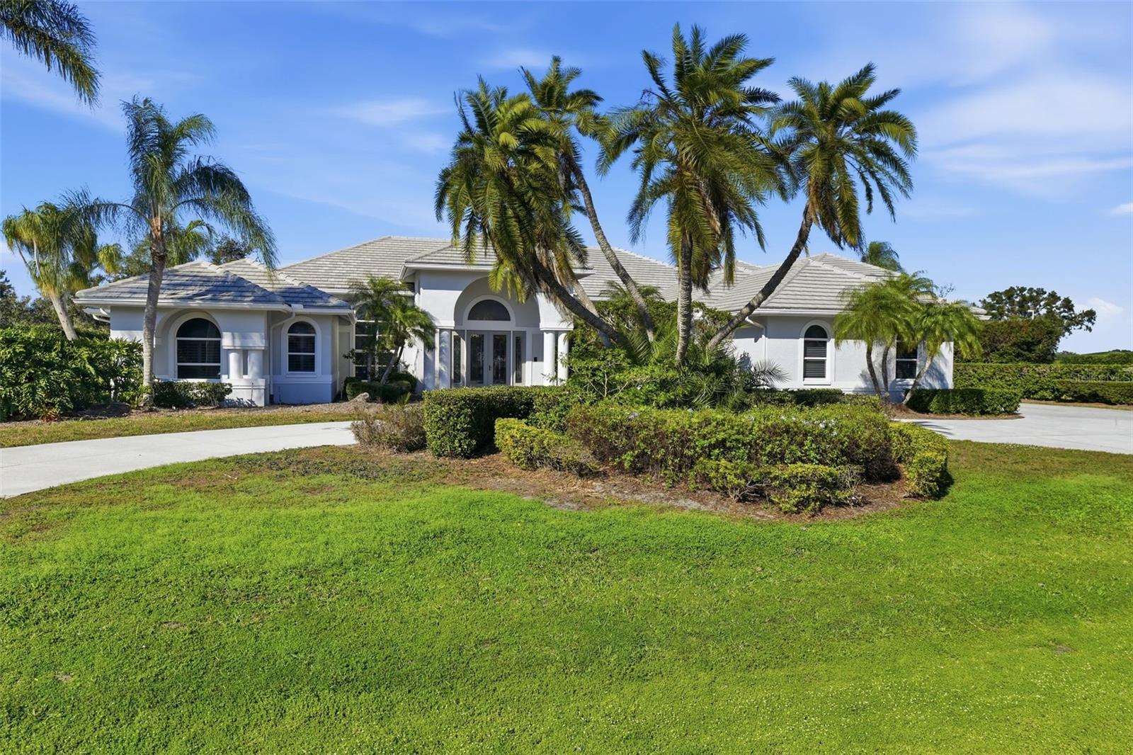 With a level of scale and versatility rarely available in Laurel Oak Estates today, this residence is set on an oversized lakefront corner lot just under three-quarters of an acre, offering exceptional privacy, long water views, and a true legacy opportunity within the community. Designed for both gracious entertaining and everyday living, the home unfolds through expansive yet inviting spaces filled with natural light and framed by soaring ceilings and tranquil lake views. Multiple living and gathering areas create an effortless flow, allowing the home to feel equally comfortable hosting large celebrations or quiet evenings at home. At the heart of the residence, the chef’s kitchen anchors the main living areas with custom cabinetry, stone surfaces, a generous center island, and a built-in wine bar, ideal for connection, conversation, and entertaining. Architectural details such as eight-foot solid doors, crown molding, and thoughtfully scaled rooms add warmth and timeless character throughout. Five private en-suite bedrooms provide comfort and flexibility, including a spacious primary suite with spa-like bath and generous closet space. A separate lakefront guest residence offers exceptional versatility and privacy, featuring northern exposure, soaring ceilings, loft space, and a private balcony, ideal as an in-law suite, art studio, private office, or retreat. Outdoor living is calm and expansive. A screened pool and spa, newly updated with new tile and resurfacing, along with a paver lanai, outdoor shower, and courtyard with fountain create a peaceful setting for relaxation and entertaining, all overlooking the lake. The .6896 acre lot provides a rare sense of openness and privacy within the community. Additional features include a circular drive, multiple garages including a separate garage for the guest residence, multiple zoned air-conditioning systems, and a newer tile roof supporting comfort, efficiency, and ease of living. Experience the best of Laurel Oak, one of Sarasota’s most sought-after gated communities, featuring a 24-hour secure guard gate, beautifully maintained grounds, and a true sense of privacy and prestige. Residents also have the option to join the renowned Laurel Oak Country Club, home to two championship golf courses, tennis, dining, and an active social calendar that makes it easy to enjoy the very best of Florida club living. This is an estate designed not just to impress, but to be lived in, shared, and remembered.