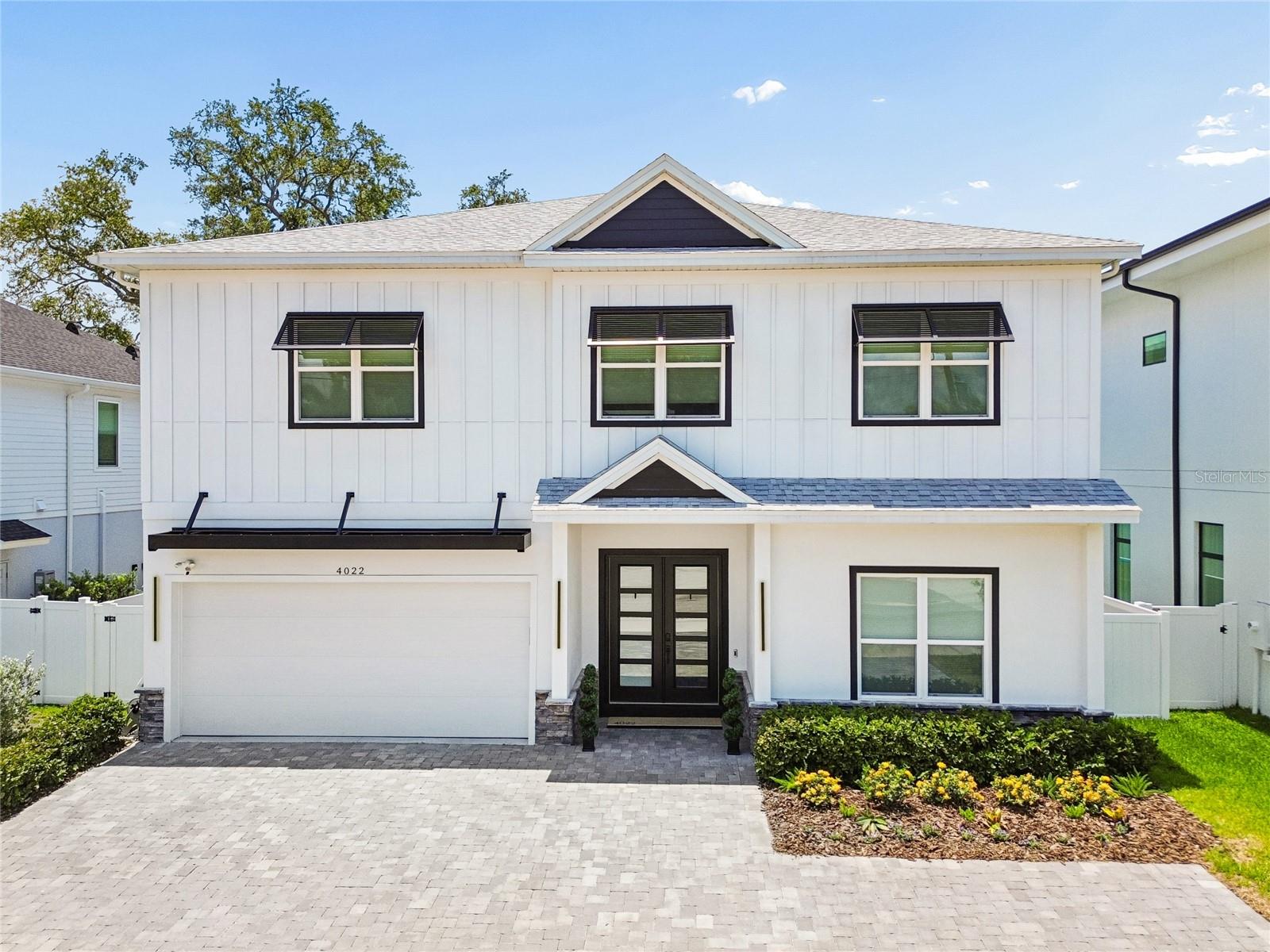 Immerse yourself in the coveted South Tampa lifestyle with this beautifully crafted and thoughtfully designed luxury residence offering 
5 bedrooms, 5 full bathrooms, a versatile flex room, and a spacious 2-car garage across 4,090 square feet of exceptional living space. A grand double-door entry welcomes you into an impressive foyer highlighted by soaring 11'4" ceilings (on both levels), impeccable craftsmanship, and stunning 7.5" Café Cannoli engineered hardwood flooring that extends throughout the entire first level and most of the second level. Automated electric blinds enhance the home's sophistication while providing effortless privacy and convenience. Designed for both elevated everyday living and seamless entertaining, the expansive open-concept floor plan is bathed in natural light and effortlessly connects the living, dining, and kitchen spaces. The chef's kitchen serves as the centerpiece of the home, featuring a complete stainless steel appliance package, quartz countertops, custom cabinetry, a massive center island, abundant storage, and an impressive walk-in pantry. Just off the kitchen, a thoughtfully designed mudroom adds functionality and organization. The first floor also includes a private guest suite with an ensuite bathroom. The striking open-air staircase leads to a spacious second-floor landing, creating a dramatic architectural focal point. Through solid-core double doors, the luxurious primary suite offers a true owner's retreat. The spa-inspired ensuite bath showcases a freestanding soaking tub, an expansive wet room with a rainfall shower, dual vanities, and a massive walk-in closet designed to impress. Bedrooms three, four, and five each feature private ensuite bathrooms, providing exceptional comfort and privacy for family and guests. The upstairs flex room offers endless possibilities as a media room, home office, fitness studio, playroom, or optional sixth bedroom. The laundry room is located on the 2nd floor as well. Outdoor living is equally impressive with a covered lanai overlooking a fully fenced, low-maintenance backyard enhanced by approximately 900 square feet of professionally installed premium turf. For those envisioning a private outdoor oasis, professionally designed pool plans have already been completed by the current owners, saving valuable time and expense. Additional highlights include an expanded paver parking pad, desirable Flood Zone X designation with no lender-required flood insurance, and zoning for the highly sought-after Plant High School district conveniently within walking distance. Just steps away from  beloved Friendship park. Combining luxury finishes, thoughtful upgrades, and an unbeatable South Tampa location, this exceptional residence presents a rare opportunity to enjoy refined Florida living at its finest!