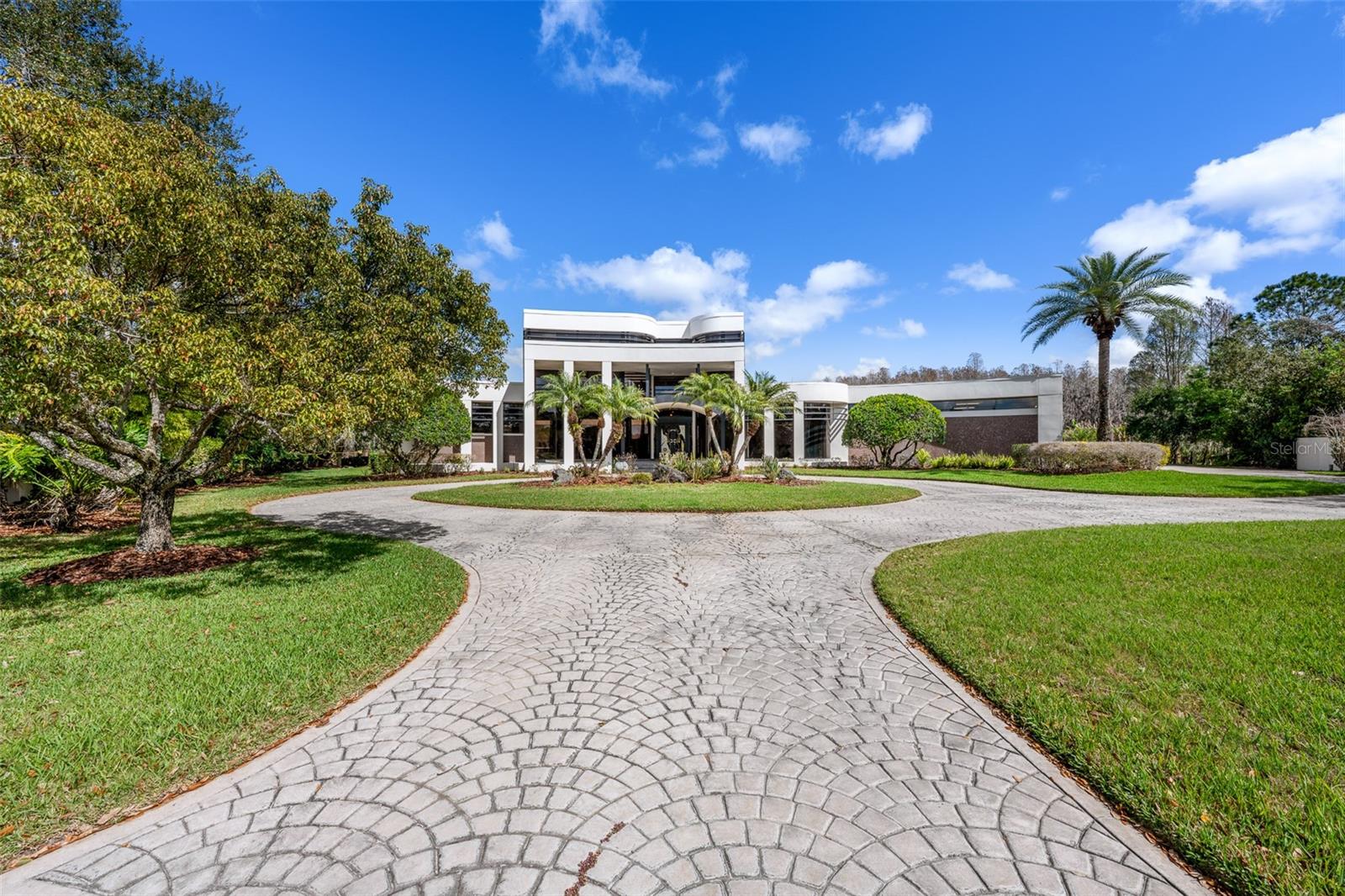 Tucked behind the gates of Cheval Polo & Golf Club, where oak-lined streets meet championship fairways, this extraordinary estate invites a life defined by space, privacy, and quiet luxury.

Positioned on over an acre at the end of a cul-de-sac, the home unfolds with a sense of scale that is both impressive and intentional, offering more than 8,200 square feet of living space with sweeping pond and golf course views. Mornings begin with soft light over the water, coffee in hand as the day eases in, while afternoons transition effortlessly between indoor comfort and outdoor escape.

Designed for both grand entertaining and everyday living, the residence balances grandeur with warmth. Soaring ceilings, refined architectural details, and expansive living spaces create a backdrop that feels both elevated and inviting. The kitchen anchors the home—open, functional, and designed for gathering—with stone countertops, a large center island, and seamless connection to the surrounding living areas, while formal spaces provide flexibility for hosting on any scale.

The primary suite offers a true sense of retreat, privately positioned on the main level with generous proportions, dual walk-in closets, and a spa-inspired bath featuring a soaking tub, separate shower, and dual vanities. Each additional bedroom is thoughtfully designed with its own en-suite, ensuring comfort and privacy for family and guests alike.

Outdoor living is equally compelling, where a screened pool and spa, outdoor kitchen, and expansive patio spaces create a private, resort-like setting designed to maximize tranquil golf and water views. Mature landscaping, a circular drive, and a four-car garage further enhance both presence and functionality.

Beyond the home, Cheval offers a lifestyle few communities can match, with 24-hour guard-gated security, championship golf, tennis, and a setting that feels worlds away while remaining effortlessly connected to Tampa’s best dining, shopping, and top-rated schools.

A rare opportunity to own a property of this scale and setting within one of Tampa Bay’s most sought-after communities—designed to live expansively and exceptionally well.