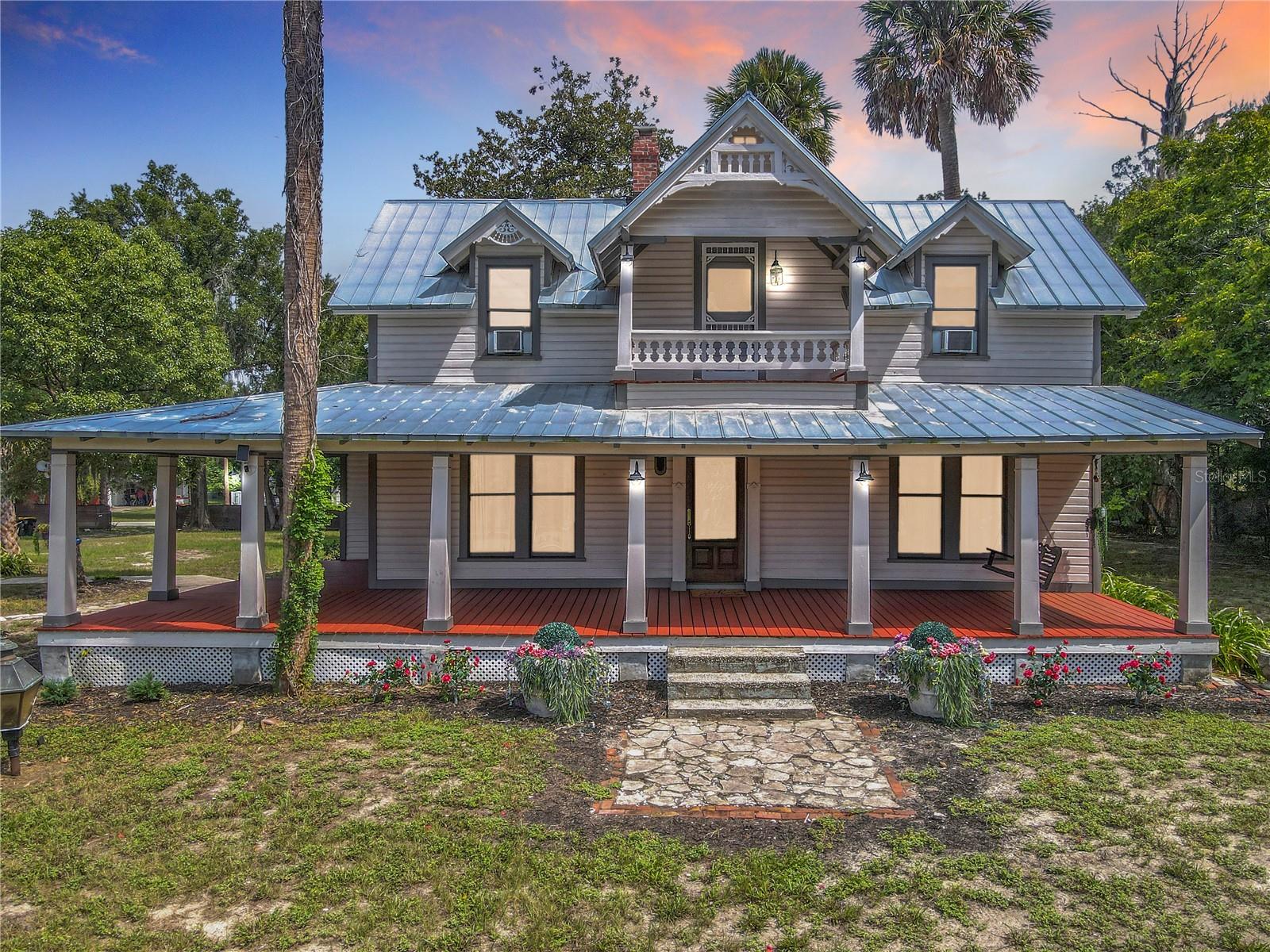 Virtually Staged. Step Into History And Discover The Timeless Beauty Of This Charming 1886 Victorian Home, A True Landmark Right Here In Orange City. Nestled On 1.76 Acres Of Peaceful, Park-Like Land, This Property Welcomes You With A Majestic Palm-Lined Driveway That Once Guided Horse-Drawn Carriages To The Front Porch. The Grand Wraparound Porch, Multiple Screened Porches, And Second-Floor Balcony Create Endless Opportunities To Relax, Host Gatherings, Or Simply Enjoy The Gentle Breeze And Shaded Outdoor Living Spaces.  Inside, Every Room Reflects Warmth And Historic Character, From The Handcrafted Woodwork To The Many Fireplaces Found Throughout. Large Windows Invite Natural Light Into The Living Room And Dining Room, Both Of Which Feature Beautiful Fireplace Details And Built-Ins.
The Updated Kitchen, Located Just Off The Dining Room, Offers Stainless Steel Appliances, A 6x6 Walk-In Pantry, And Easy Access To The Back Screened Porch And Charming Garden Area.  The Main Level Also Includes A Bright, Spacious Room With A Fireplace That The Previous Owners Used As A Primary Suite, But It Would Also Make A Wonderful Sitting Room, Office, Library, Or Guest Space.
Use The Beautiful Wooden Staircase At The Front Of The Home To Reach The Second Floor, Where You’ll Find The True Primary Suite Featuring A Large 6x16 Walk-In Closet, A Soaking Tub, And Peaceful Views Of The Grounds. Across The Hall Sits Another Bedroom.
One Very Unique Feature Of This Property Is The Private Back Entrance, Located Off The Kitchen And Screened Porch, Providing Direct Access To The Third Bedroom Upstairs Without Going Through The Main Living Areas. This Is Perfect For Someone Who Works From Home, Needs A Private Studio Or Office, Or Wants A Comfortable Guest Space With Extra Privacy. Outside, You’ll Find A Detached Two-Car Garage Complete With An Electric Vehicle Charging Station, Along With Ample Areas For Gardening, Pets, Play, Or Simply Enjoying The Quiet Surroundings. The Property Feels Tucked Away Yet Remains Convenient To Everything — Shopping, Restaurants, Medical Facilities, And More. Blue Spring State Park Is Only Minutes Away, Along With Downtown Deland, New Smyrna Beach, Downtown Orlando, And I-4.
 This Is A Rare Opportunity To Own A Beautiful Piece Of Orange City’s History With All The Charm, Space, And Timeless Appeal You’ve Been Looking For.