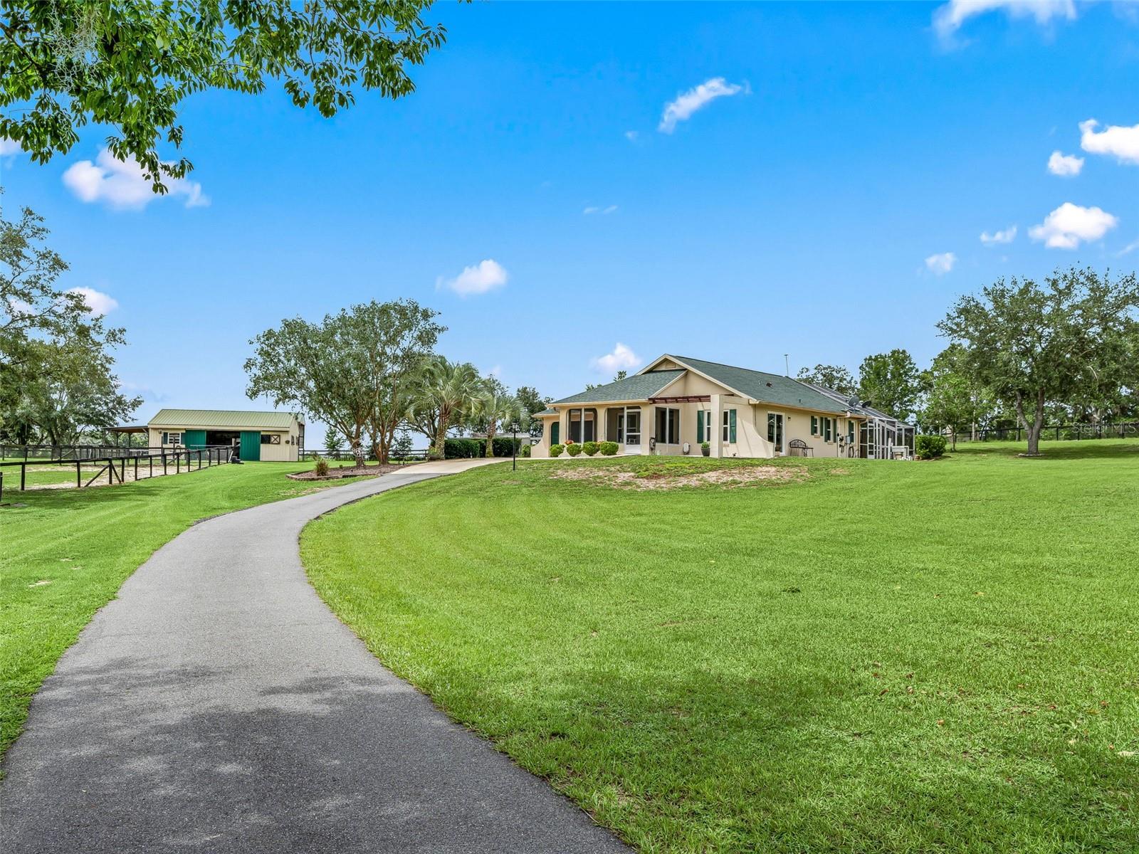 Take a deep breath - you have found the one! This picturesque mini farm is located right off 140th Avenue for easy access to Ocala and Dunnellon. Just shy of 5 acres - high and dry - this property is situated on a quiet, paved, dead-end street. The automated gated entryway leads up the paved driveway past 4 manicured, cross fenced paddocks and the riding arena. The home and 2 stall barn are located in the back of the property overlooking the gently rolling property. The home features a front screened porch with wood-look tile flooring. Inside, you will find an open concept living space with hardwood floors and vaulted ceilings. The kitchen boasts granite countertops and newer stainless steel appliances and a closet pantry. The two bedrooms are located in the back of the home - both with pool access! The primary suite features a renovated bathroom with tiled walk-in shower, dual vanities, separate water closet, plus a walk-in closet. The attached two car garage has a drywalled storage area and was previously under heat and air. The spacious, private pool area is completely screened with the solar heated saltwater pool - surrounded by mature landscaping. The two stall barn offers a center aisle and a large tack/feed room. There is also a lean-to on one side for equipment, or possibly additional stalls, if needed. Behind the barn are two large, covered, trailer ports and additional workshop spaces and storage sheds beyond. Additional updates and features include: new architectural shingle roof 2024, Generac standby generator in 2023 with propane tank, and newer double pane windows. Schedule your tour of this gem before it gets away!