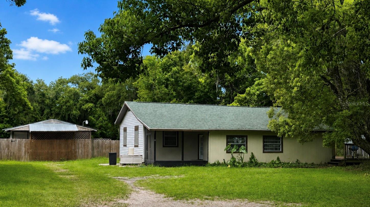 Short Sale. RARE DUAL LIVING OR DUAL INCOME OPPORTUNITY in the heart of Zephyrhills! Situated in a fully fenced half-acre lot, this unique property offers exceptional flexibility for homeowners, investors, multigenerational families or buyers looking to offset their mortgage with rental income. The main residence features approximately 2,000 square feet of living with 4 bedrooms and 2 full bathrooms. Inside you will find a mudroom entrance, spacious kitchen with abundant cabinetry, dedicated laundry room, beautiful refinished wood floors, and a fresh coat of paint completed prior to the current tenant's occupancy. Enjoy relaxing on the screened front porch or the large wood deck overlooking the property.
Tucked behind the main home is a separately fenced and detached 2 bedroom, 1 bath guest house (mother-in-law-suite) offering approximately 800 square feet of living space plus an oversized attached storage room. The guest house has also been recently updated with fresh interior paint and new laminate flooring prior to the new tenant occupancy.

Additional features include a long private driveway, well and septic, separate fenced living areas, mature trees, and a peaceful setting still only minutes away from shopping, restaurants, schools, medical facilities, and major highways.