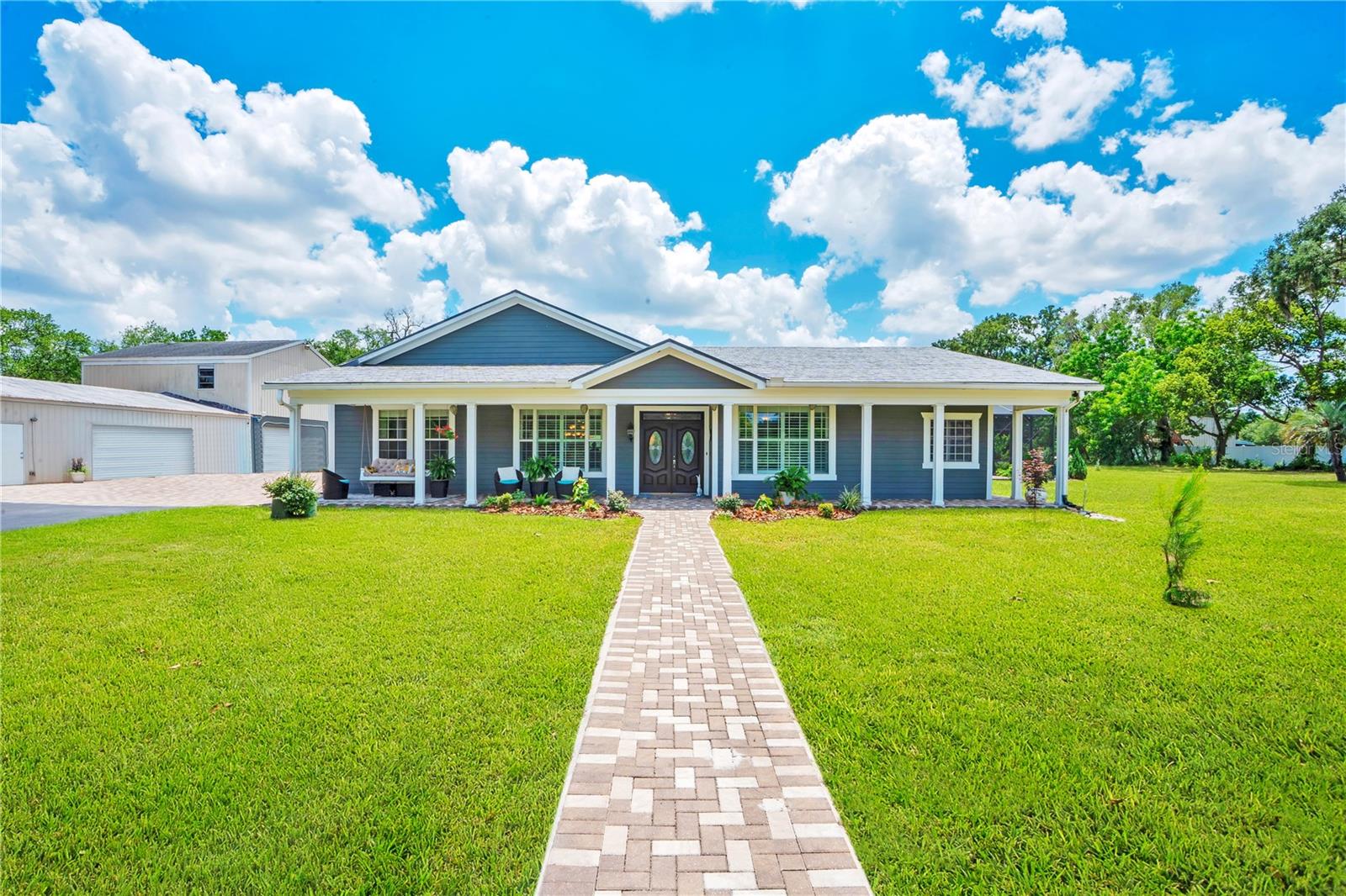 UNICORN. A magical property but also truly one of a kind. Enter the 5.46 acre property through the automated front gate (controlled by smart phones & remotes). Equestrian dreams come true with an 11 stall horse barn & tack room. Separate hay barn. Separate back entry to the property. The main house is 3600 square feet of custom built luxury, including a 50 year, aluminum shingle roof. The double door entry welcomes you with Brazilian cherry hardwood flooring in the formal living & dining rooms. The perfect spot to highlight your baby grand or favorite piece of exquisite art. Light & bright thanks to recessed lighting & a tray ceiling above the dining table. Continue forward to the chef’s dream kitchen. Granite counters. Travertine flooring. Floor to ceiling, custom cabinetry with a massive, hidden, walk-in pantry. A unique 3’ round, prep sink is the focal point along with a classic range hood which matches the stainless steel appliances: double convection ovens, lux fridge/freezer, hybrid induction cook top. Under cabinet lighting, a lighted curio cabinet, & 110V AC receptacles above the cabinets. 
The primary suite is a true getaway. Durable laminate flooring, electronic blackout shades, tray ceiling with dual fans, & a dream, custom, walk-in closet. Who needs a spa when you have a 12’ x 22’ en suite bathroom featuring two spacious vanities & sinks with a sitting area in between? The walk-in shower includes 7 heads & a detachable sprayer. There is also a separate soaking tub & 2 linen closets. 
The 3 way split floor plan is ideal for privacy.  
The family room is pristine with luxurious, lush carpeting & plantation shutters. There is also a secondary eating space, complete with built-in cherry China cabinets, a granite top bar & mini fridge. 
Sliding glass doors offer a view of the custom paver pool deck, heated, salt water pool & spa as well as the waterfall & fire element. The summer kitchen allows owners to enjoy the highest quality Florida lifestyle. 
Pay attention, here comes the quality details you won’t find anywhere else: SIP (structural insulated panel) exterior construction with HardiPlank siding, a whole house air exchanger in the attic (which is also air conditioned), 5 zone A/C unit, straps from all corners of the house to the roof, R24 closed cell foam walls & R40 closed cell foam ceiling, and a 3ft thick slab with 5/8 rebar every 12 inches. One inspector said this slab has more steel than some of the downtown skyscrapers! Car lovers welcome to paradise. The 6 car garage could easily become an 8 car but the end unit is currently used as a workshop. Above the workshop is a 2 bedroom, 1 bathroom apartment with a living room & kitchen. Rent it out as an income property or use it for family. So much potential! Beside the garage is an ADU that could also be renovated into a rental. Currently used as storage. 
Bonus features: Interior room w/re-bar & filled cement blocks & 1/4 steel plate on ceiling, a direct tornado proof safe room. A 16 KW whole house generator, central vacuum with floor sweep ports in laundry room & kitchen, dual tankless water heaters, 2026 pool filter & motor, 6” crown & base molding throughout home, 50 amp RV outlet, irrigation lines with separate TAW perfect pressure pump for over 90 trees and plants, 350 gallon buried propane tank for pool and spa heat, & over 700 feet of 6 feet tall vinyl privacy fencing.  This one is truly special and must be seen to believe & appreciate.