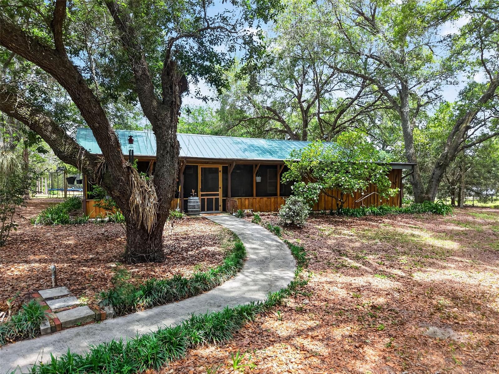 Acreage, equestrian, approximately 5-acre turnkey furnished horse property — Umatilla home for sale offering Old Florida living with room to roam, relax, and make it your own. Leave the noise behind and step into your own private, secluded retreat in beautiful Umatilla. This picturesque property showcases a blend of majestic live oaks, mature crêpe myrtles, and thoughtfully maintained landscaping that creates a quiet, peaceful, and serene wooded paradise with a true country living feel.

Whether you envision an equestrian retreat, a peaceful cabin tucked beneath the oaks, or the site of your custom dream home, the possibilities here are truly endless. With usable land, open space, and a private setting, this property is ideal for those seeking acreage, privacy, and flexibility. Outdoor features include a pergola with picnic area, perfect for relaxing or entertaining while enjoying the scenic surroundings. There is also an empty fish pond that could easily be restored into a tranquil koi pond or water garden.

Located in the back pasture, you’ll find a spacious pole barn with loft offering excellent storage and functional space, with strong potential for conversion into horse stalls, tack space, or a fully customized equestrian setup. This horse-friendly property offers room for animals, equipment, and recreational use. The property is equipped with two electrical sub-panels, one located at the front and another in the barn, making it ideal for RV hookup, camper parking, or additional equipment. An underground irrigation system services the property, helping maintain the lush landscaping and mature trees with ease.

Turn-key and fully furnished, this property comes complete with linens, towels, kitchen utensils, tables, chairs, beds, and household essentials, making it a rare opportunity for buyers seeking a vacation rental, Airbnb, VRBO, or income-producing property. It also serves perfectly as a private weekend getaway or peaceful retreat.

Conveniently located near Alexander Springs and the Ocala National Forest, the area is well known for horseback riding, trail riding, hunting, and outdoor recreation. The property is also just a short distance from the Lake Yale boat ramp, offering easy access to fishing, boating, and abundant Florida wildlife, while still being close to grocery stores and everyday conveniences.

If you’re searching for acreage, privacy, equestrian potential, and income opportunity all wrapped into one beautifully landscaped estate, this property delivers. Schedule your private showing and experience it firsthand.