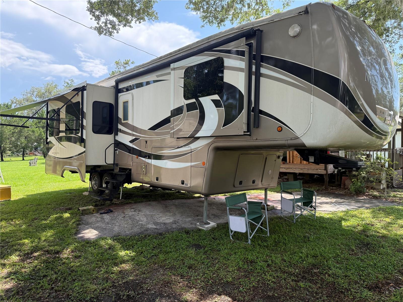 UNIQUE OPPORTUNITY – YOU OWN THE LAND! TAKE ADVANTAGE OF YOUR MOBILITY!!
Welcome to Camper's Holiday, a friendly and welcoming 55+ gated community where resort-style living meets affordability. Whether you're looking to downsize, escape the winter months, or find the perfect full-time residence, this property checks all the boxes!
INCLUDED IS A BEAUTIFULLY MAINTAINED 36-FOOT 2015 DRV MOBILE SUITES FIFTH WHEEL designed for residential comfort with luxury amenities throughout. Inside, you'll find a spacious kitchen featuring a center island with double sink, full-size stainless steel refrigerator, dishwasher, oven, microwave, and abundant cabinetry. The inviting living area includes a full-size sofa that converts into a queen-size bed, comfortable recliners, and a Sony surround sound system—the perfect place to relax after a day of enjoying the Florida sunshine.
The private bedroom features a KING-SIZE BED, walk-in closet, convenient washer/dryer combo, and a full bath. Additional highlights include TWO AIR CONDITIONING UNITS (one with a heat pump), an Insta-Hot water heater, four slide-outs, two awnings, a six-point automatic leveling system, a 50-foot hose reel, bike rack, and exceptional storage throughout. Designed with comfort in mind, this luxury fifth wheel truly feels like home. Don't need the camper? The seller is offering the opportunity to purchase the land only if desired! 
Outside, the covered carport, screened room, and storage shed provide plenty of protected space for vehicles, golf carts, hobbies, or entertaining. With a little TLC, the screened room offers an excellent opportunity to expand your outdoor living space.
Camper's Holiday offers an active, low-maintenance lifestyle with outstanding amenities, including an Olympic-size geothermal swimming pool, clubhouse, library, shuffleboard courts, playground, fire pits, and a full calendar of activities including bingo, karaoke, poker, dinners, and live entertainment. Outdoor enthusiasts will appreciate Lake Sparkman, located within the community, complete with a fishing pier and private boat ramp.
The low HOA fee of just $510 per quarter additionally includes cable TV, high-speed internet, water, and trash service, making this an incredible value. Don't miss your opportunity to own a piece of paradise in one of Brooksville's most welcoming active adult communities!