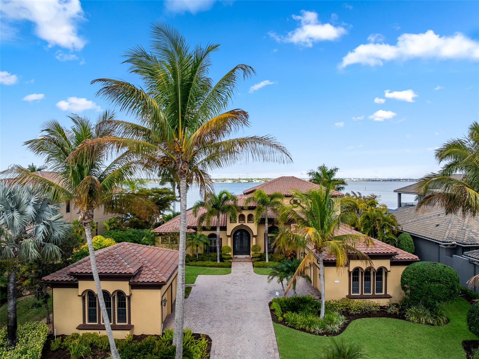 4003 Hawk Island Drive, Bradenton FL

Positioned along the picturesque private street that defines Hawk Island, this waterfront estate delivers architectural scale, exceptional privacy, and direct boating access inside one of Bradenton’s most exclusive guard gated communities. With a single road serving the entire peninsula, the setting feels discreet and insulated, yet close to everything that makes life on Florida’s Gulf Coast so desirable.

Extensively refreshed with a new roof, new interior and exterior paint, and new flooring throughout, the home presents with a clean, cohesive aesthetic. Inside, beautiful 18 foot ceilings elevate the main living areas, bringing in natural light and showcasing long water views from nearly every primary space.

The kitchen anchors the home with generous proportions and seamless connectivity to both formal and casual living areas, designed for everyday living and entertaining without feeling segmented. Expansive glass doors open to a sprawling covered lower lanai, while the upper open air terrace captures elevated sunset views and coastal breezes.

The floor plan was intentionally designed for flexibility. In addition to the primary suite, a true second master suite offers comfort and separation for extended guests or multigenerational living. Upstairs, a substantial bonus room and private living area create an ideal retreat for older children or visiting family, offering independence while still connected to the home’s central spaces.

Two dedicated office spaces support a work from home lifestyle, including a main office with a private flex room positioned just behind it, ideal for a curated wine room, fitness studio, or secure specialty space tailored to the next owner’s preferences.

Outdoor living unfolds across multiple seating areas and is anchored by an oversized pool and spa, along with a separate soak pool that enhances the resort-style setting. A private dock with lift and an observation and fishing pier extend from the rear of the property. With water exposure on both sides of the residence, the views and atmosphere feel expansive, while the positioning remains composed and protected, a rare advantage in Manatee County waterfront living. Enjoy sunrise over the Manatee River where dolphin, rays, sharks, and coastal fish feed in the shallows just offshore.

Car enthusiasts will appreciate the four car garage configuration, including two detached bays, along with an oversized drive offering additional parking and a strong sense of arrival. Mature, lush landscaping surrounds the property, reinforcing its privacy and established character.

Convenient to Gulf beaches, private golf clubs, dining, no-bridge boating access to Anna Maria Island and Tampa Bay, and the airports of Sarasota and Tampa, 4003 Hawk Island Drive presents a distinctive opportunity within a tightly held waterfront community defined by scale, discretion, and lifestyle.