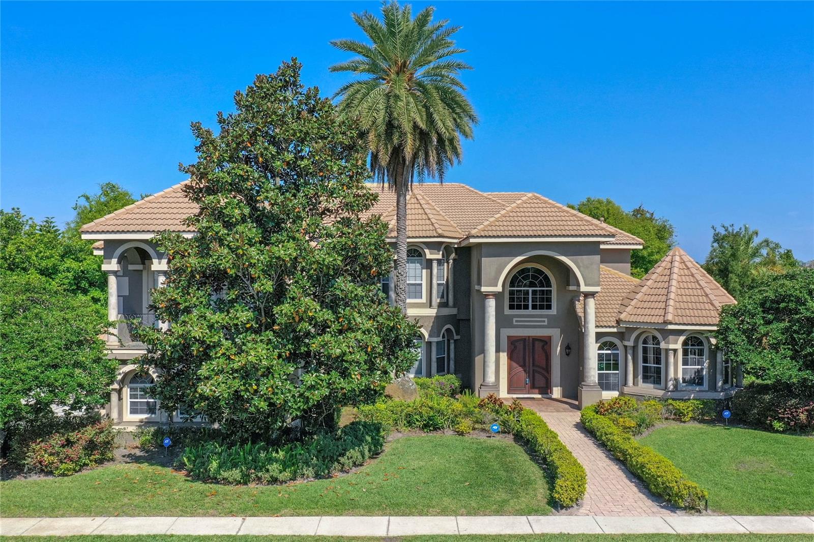 Gorgeous views are plentiful in this lakefront Windermere home.  Located on Lake Whitney in the manned, gated community of Reserve at Belmere.  6 bedrooms, 5.5 baths plus huge game room complete this home of 5,873 square feet.  The first thing you notice upon entering is the dramatic wood staircase.  Two story family room is has an open walk-way around the top lined with bookcases.  First floor Primary Bedroom is oversized and allows room for a sitting area where you can enjoy the view along with your morning coffee.  The Primary Bathroom has double sinks, large jetted soaking tub and walk-through shower.  Closet has custom built-ins.  Patio door for easy access to enjoy pool, lake view and boat dock.  Large kitchen with huge double islands is perfect for the chef in the family!  Multiple windows flood the area with natural light and lake views.  Also on the first floor is an additional bedroom with private bath for guest area as well as covered patio.  Back staircase takes you to right outside huge game room with wet bar.  Multiple front and rear balconies add additional usable space to the home.  4 additional large bedrooms are located on the second floor.    Exterior features include boat dock with lift, screened pool, outdoor shower, access to pool bath.  4 car side-entry oversized garage.  Front and back gate access adds to prime location.  Just minutes to major highways, first class shopping and all the attractions.