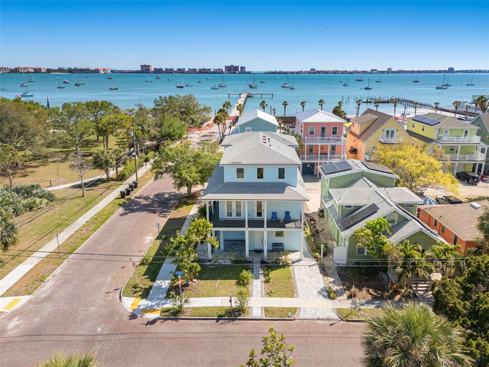 BIG PRICE DROP! Newer construction modern coastal style home right in the heart of Gulfport. One block from the water and mere steps from all of the local favorites on Beach Drive. This three-level block construction home is a fortress with impact rated windows and doors. The oversized garage and corner lot provide ample parking for cars, golf carts, boats, and anything else you can think of. All five bedrooms have their own ensuite and each floor boasts a separate powder room. The open concept kitchen stuns with quartz countertops, soft close shaker cabinetry, high end Samsung appliances, and luxury lighting fixtures. Surrounding the entire second floor is a beautiful wrap around porch with marvelous water views that provide the perfect space for entertaining and taking in the Florida sunsets. The water views are further amplified off the third floor balcony beyond the loft and wet bar. Your own private elevator connects each floor making this residential masterpiece functionally flawless. Smart home features include a complete home security system, cameras, MyQ garage doors, and a Schlage smart lock. Other amazing features are the luxury vinyl flooring throughout, Eemax tankless hot water heater, recessed energy efficient LED lighting, and it can come fully furnished. For the investor looking to add a crown jewel to their portfolio please inquire about the financials and pro forma projections. Call today and be the envy of family, friends, and neighbors!