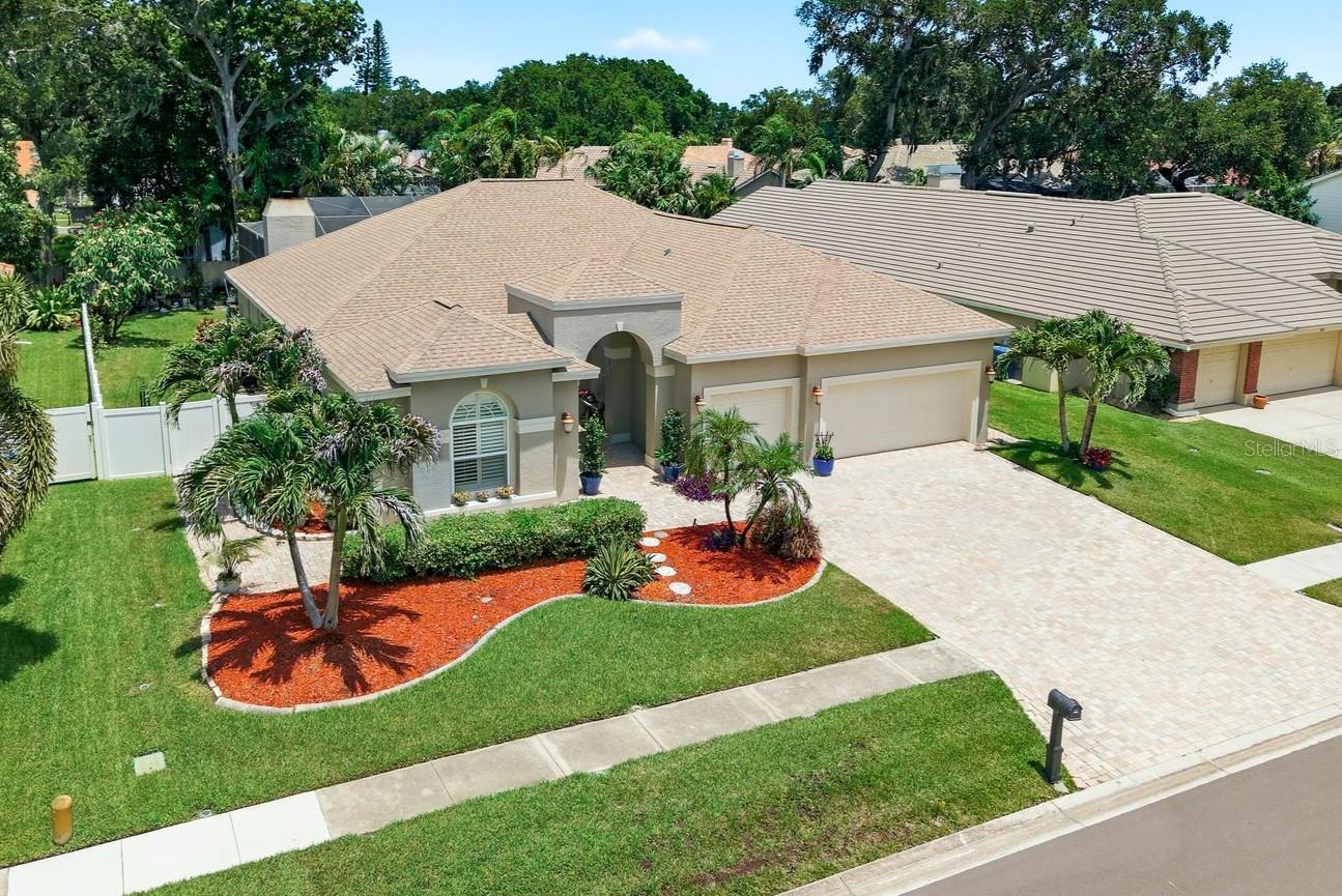 Finding a home in Oak Trail is uncommon. Finding one with a detached Flex Space/Additional Dwelling Unit (ADU), 4 bedrooms, 3.5 bathrooms, a three-car garage, a private pool, and zoned for top-rated schools is truly exceptional. Set on an oversized quarter-acre-plus homesite, this beautifully maintained residence offers the space, flexibility, and lifestyle that today's buyers desire. The thoughtfully designed floor plan provides multiple living and entertaining areas, while the kitchen serves as the heart of the home with granite style countertops, stainless steel appliances, abundant cabinetry, and views of the main gathering spaces. Adding to the home's appeal is the detached Flex Space / Additional Dwelling Unit (ADU), completely separate from the main residence. Whether utilized as a private home office, guest retreat, fitness studio, hobby room, media room, creative workspace, or multi-generational living area, this versatile space provides endless opportunities to fit your needs. Outside, a cathedral-screened pool enclosure, expansive paver patio, and large fenced backyard create the perfect setting for enjoying Florida's year-round outdoor lifestyle. Recent improvements include a 2020 HVAC system and a 2022 water heater, while the three-car garage offers exceptional storage and convenience. Ideally situated just minutes from Palm Harbor University High School and just minutes from everything Palm Harbor has to offer, this is a rare opportunity to own one of Oak Trail's most complete properties.